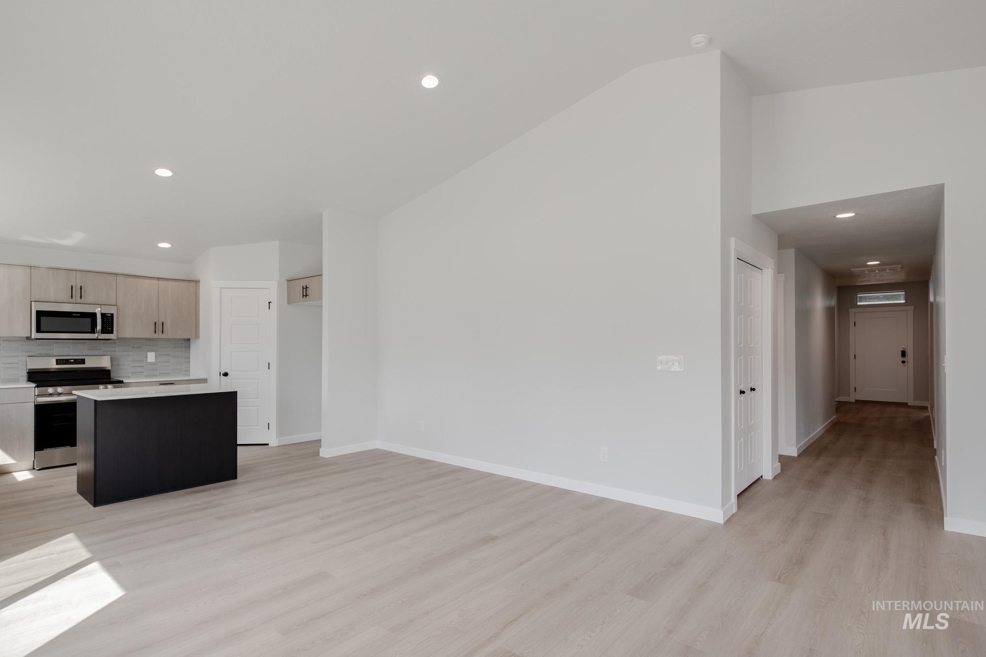 Kitchen featuring recessed lighting, a center island, stainless steel appliances, light wood finished floors, and tasteful backsplash