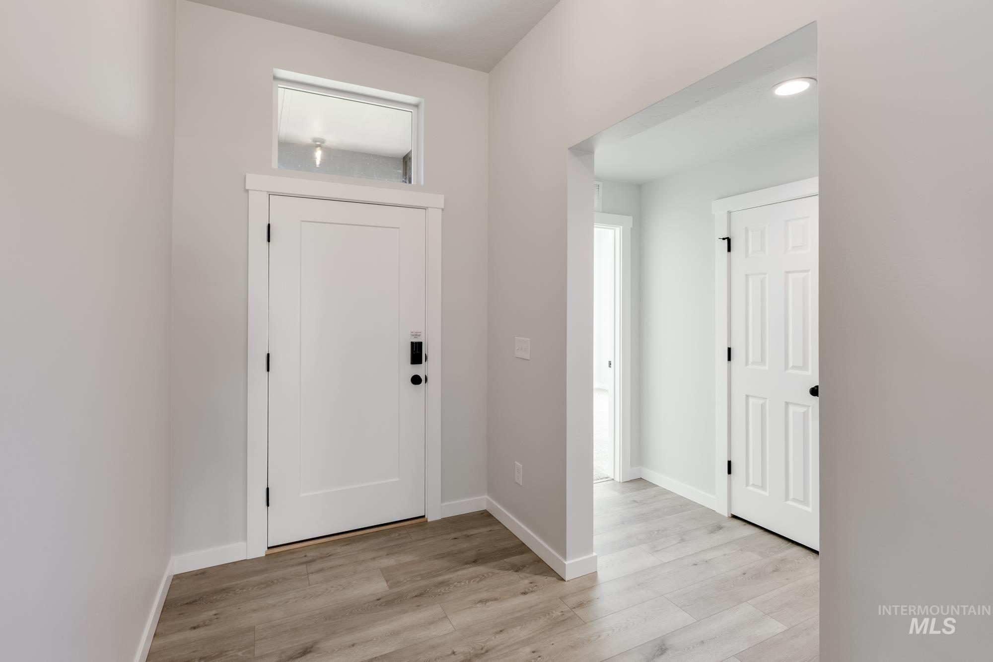 Foyer featuring light wood finished floors and baseboards