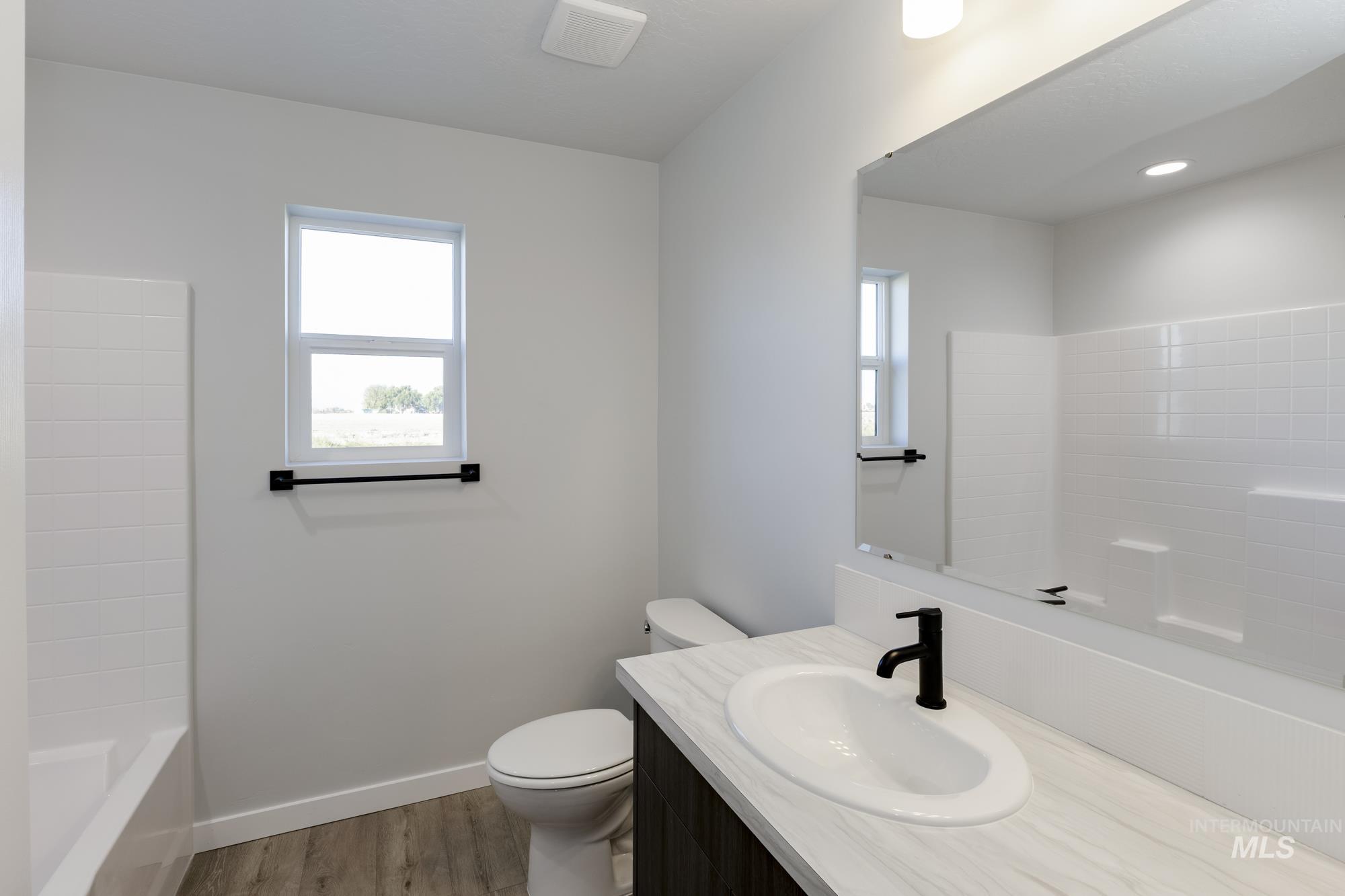 Bathroom with vanity, light wood-style floors, and tub / shower combination