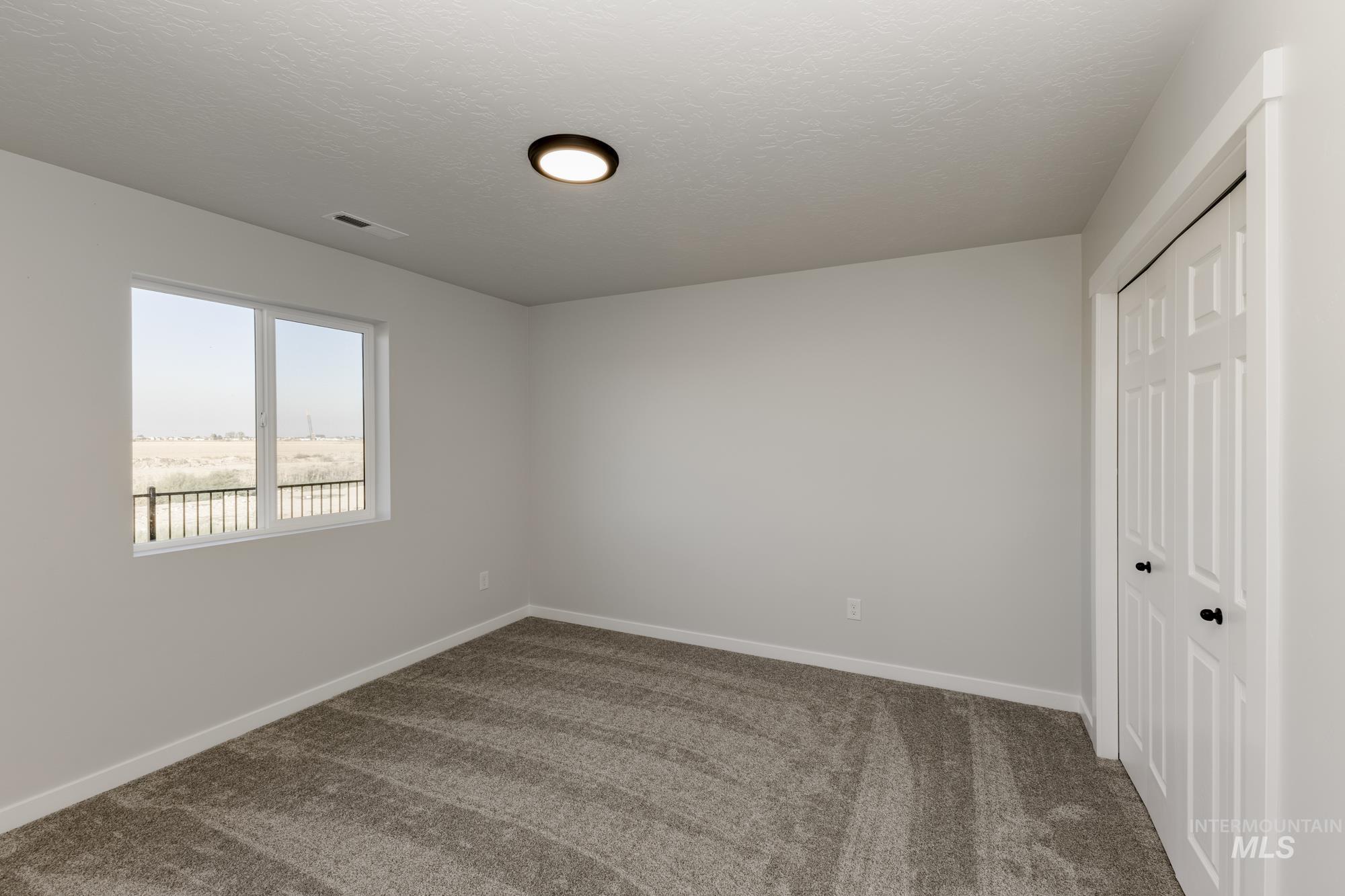 Unfurnished bedroom featuring carpet, a closet, and a textured ceiling