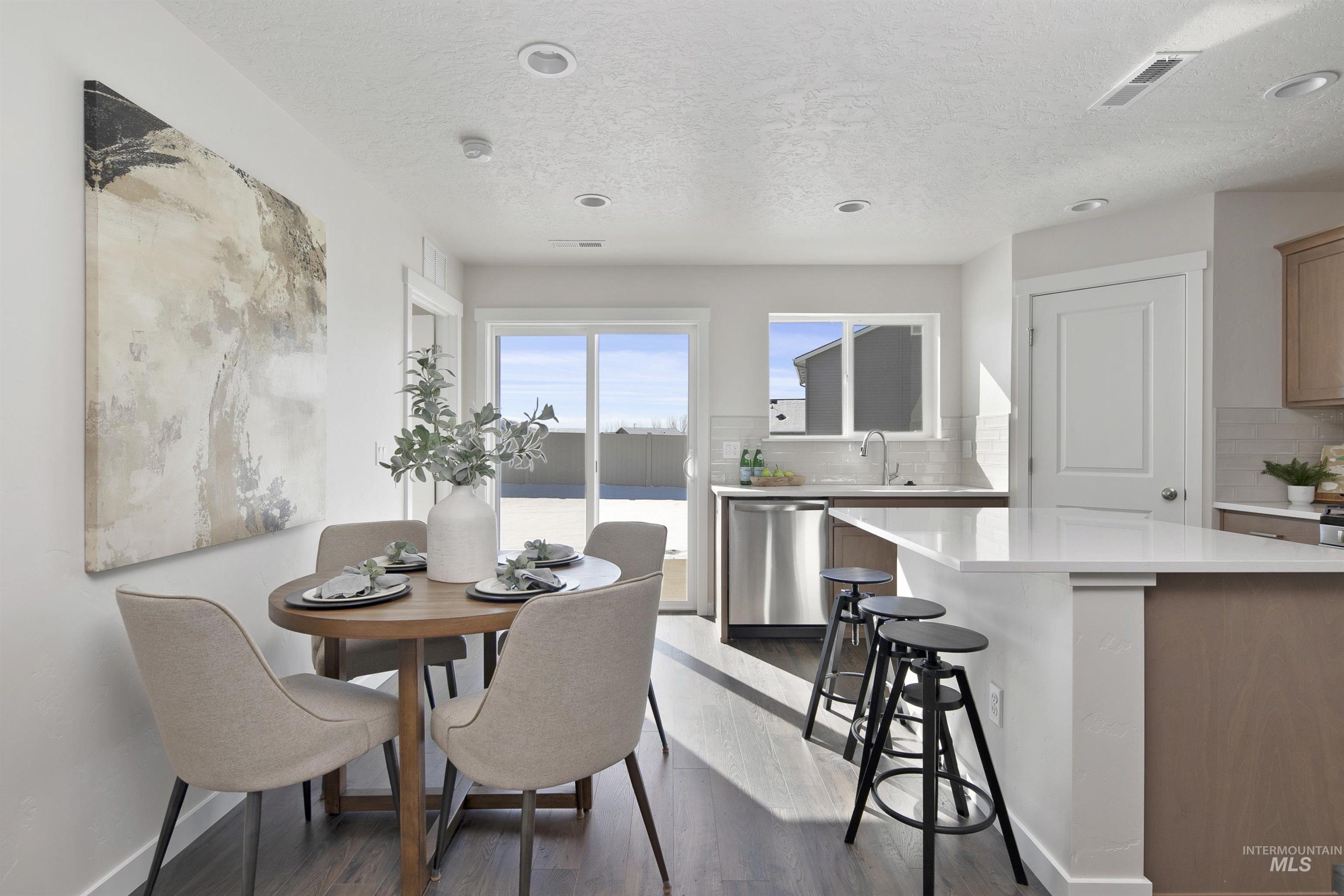 Dining space with dark wood-style floors, a textured ceiling, and recessed lighting