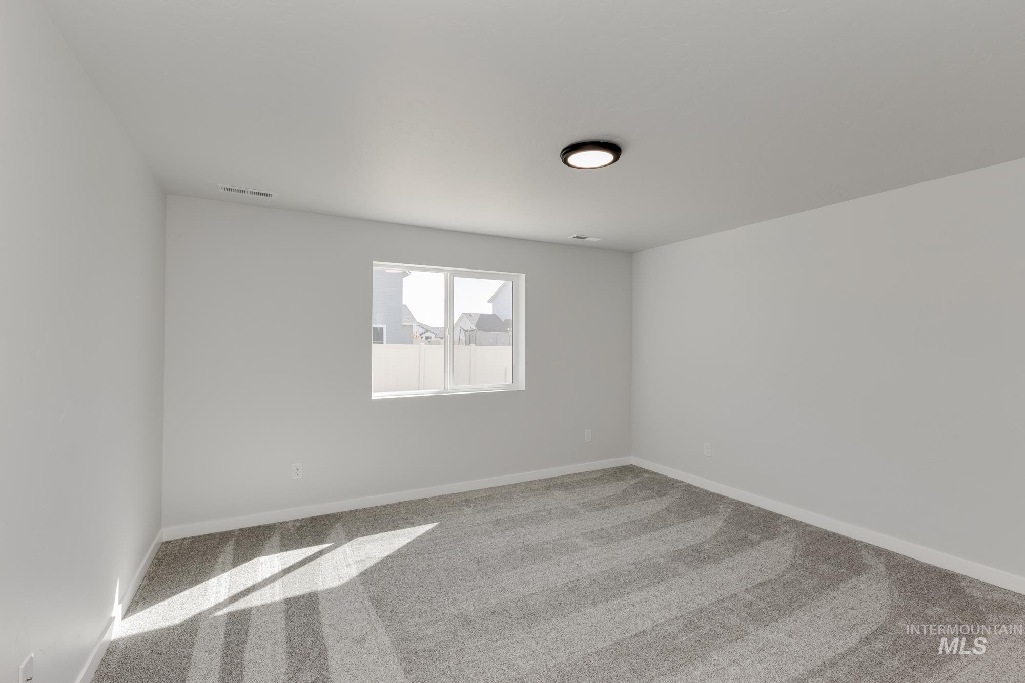 Carpeted spare room with baseboards