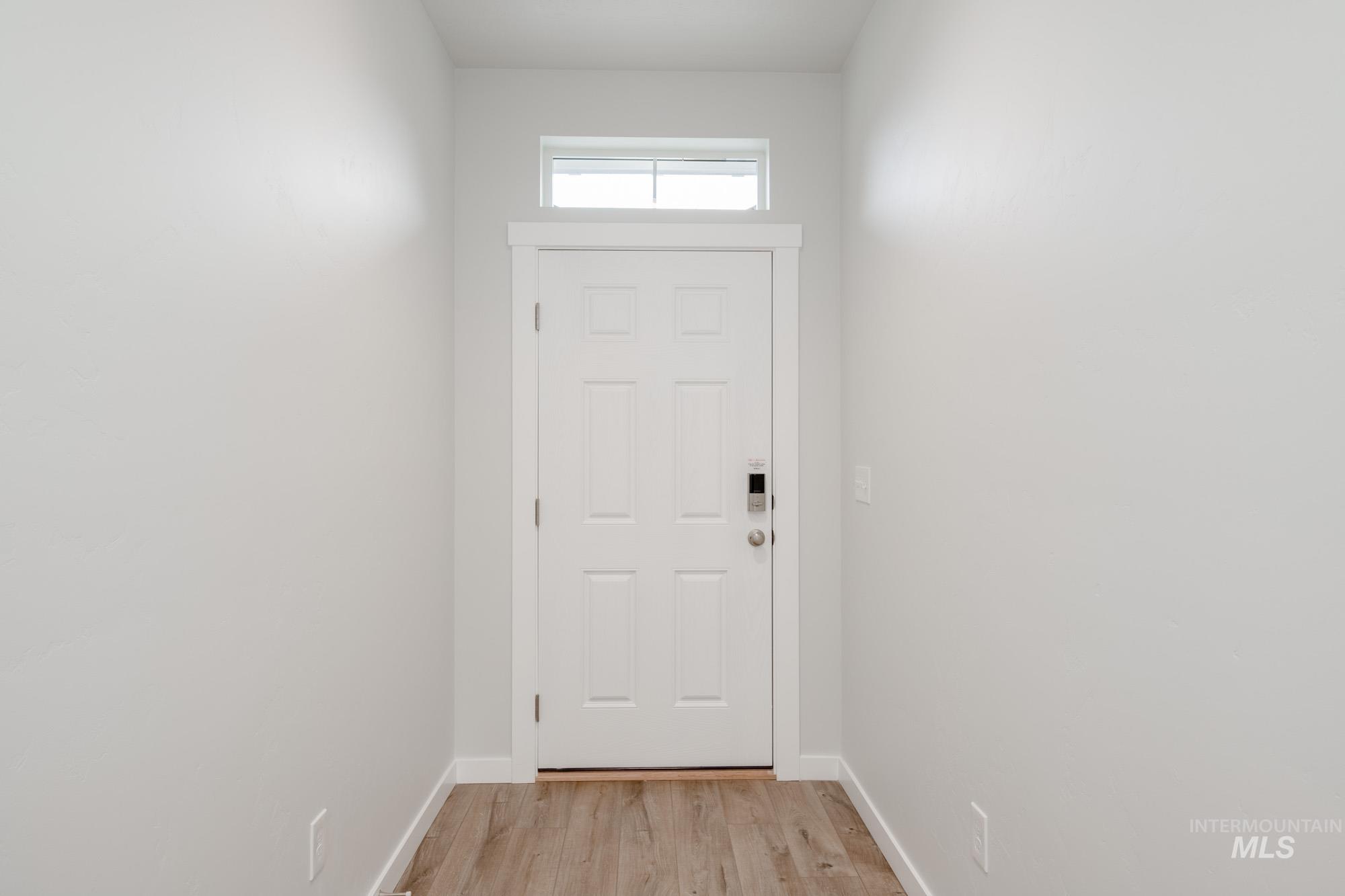 Doorway to outside with wood finished floors and baseboards