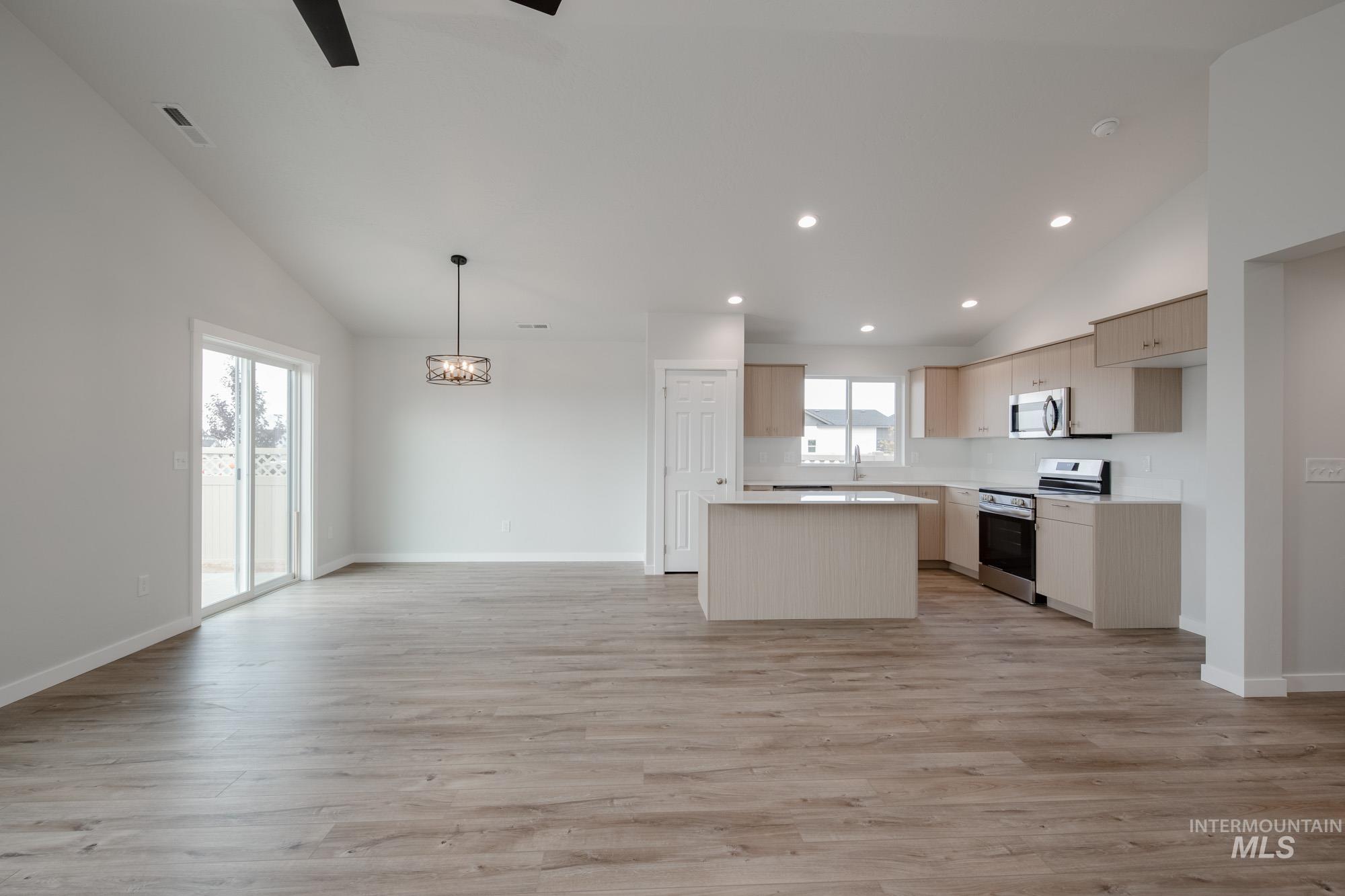 Kitchen featuring a center island, open floor plan, light countertops, appliances with stainless steel finishes, and recessed lighting