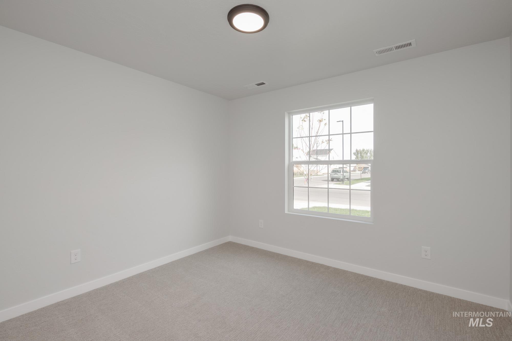 Spare room featuring baseboards and light carpet
