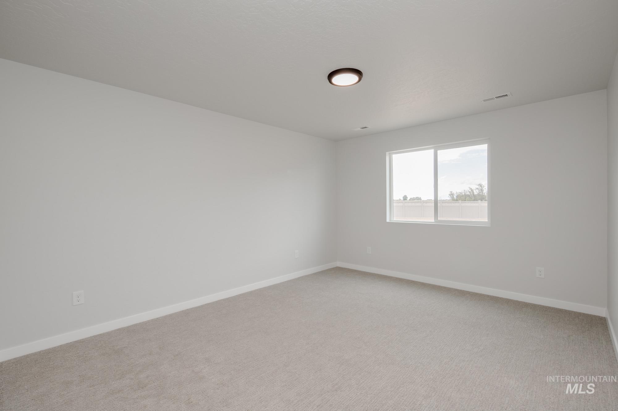 Unfurnished room featuring baseboards and light colored carpet