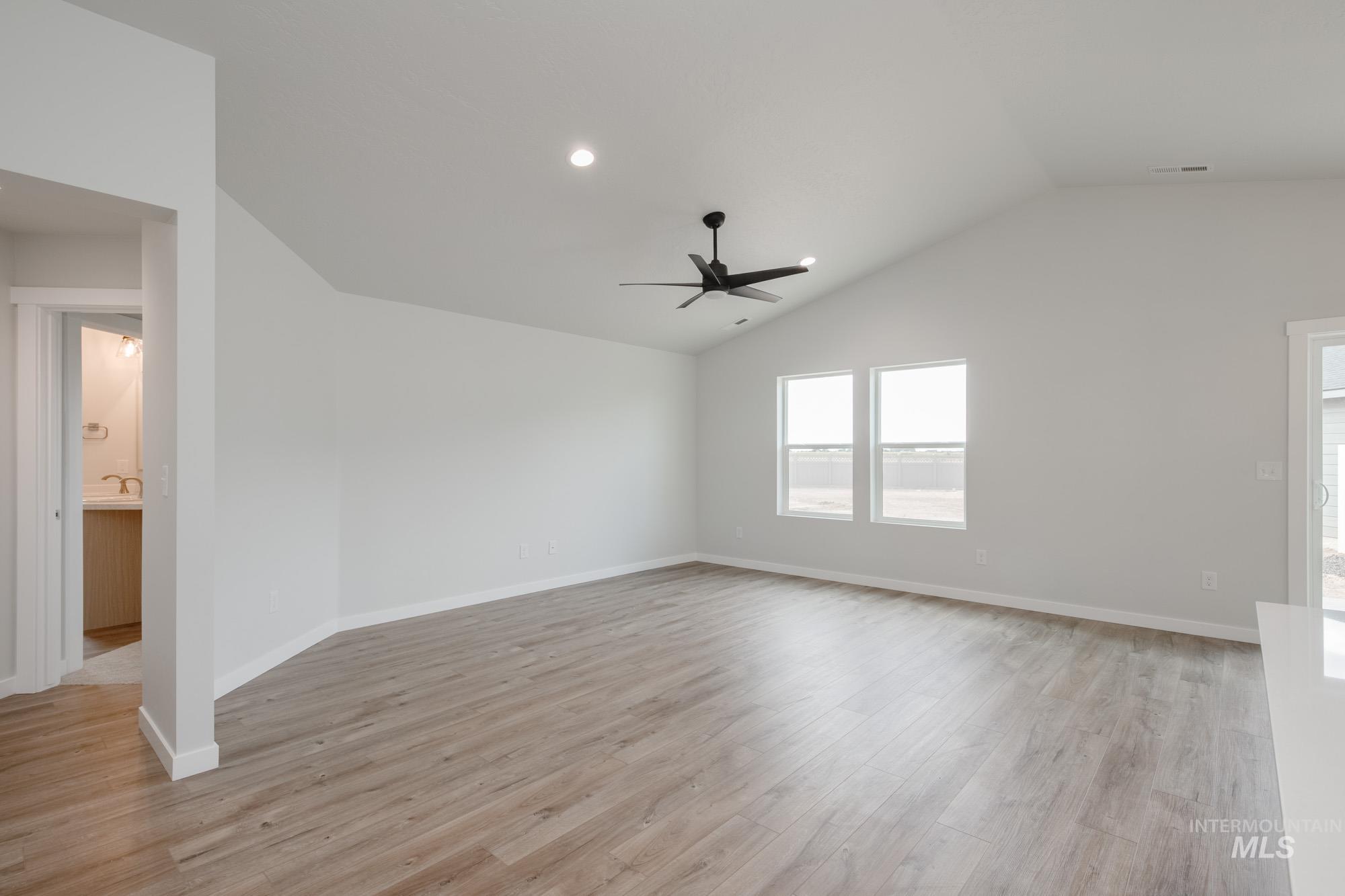 Unfurnished living room featuring light wood-style floors, lofted ceiling, recessed lighting, and ceiling fan