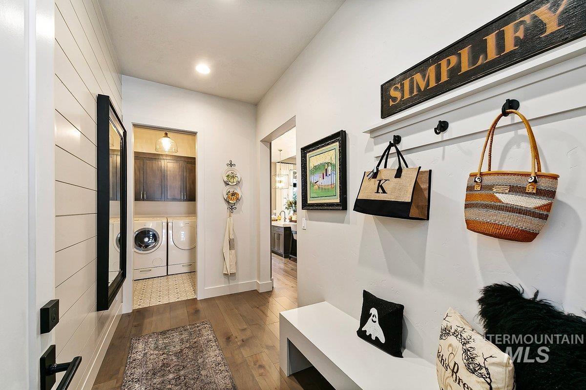 Mudroom featuring dark wood-style flooring, washing machine and clothes dryer, and recessed lighting