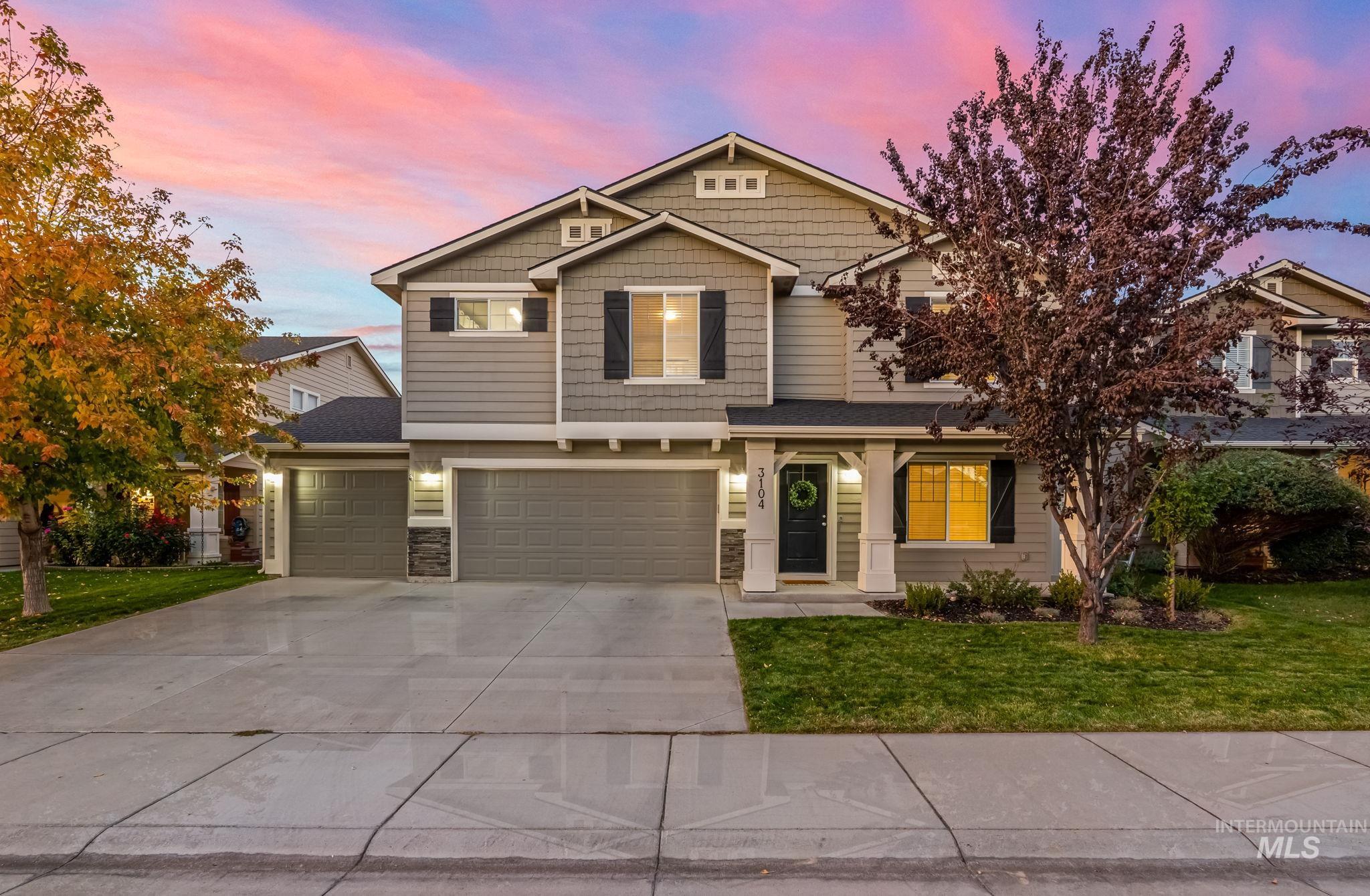 Craftsman inspired home with concrete driveway, a front yard, an attached garage, covered porch, and stone siding
