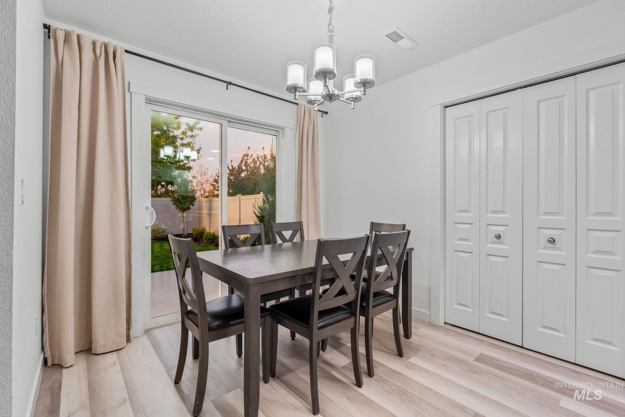 Dining space with light wood-type flooring and a chandelier
