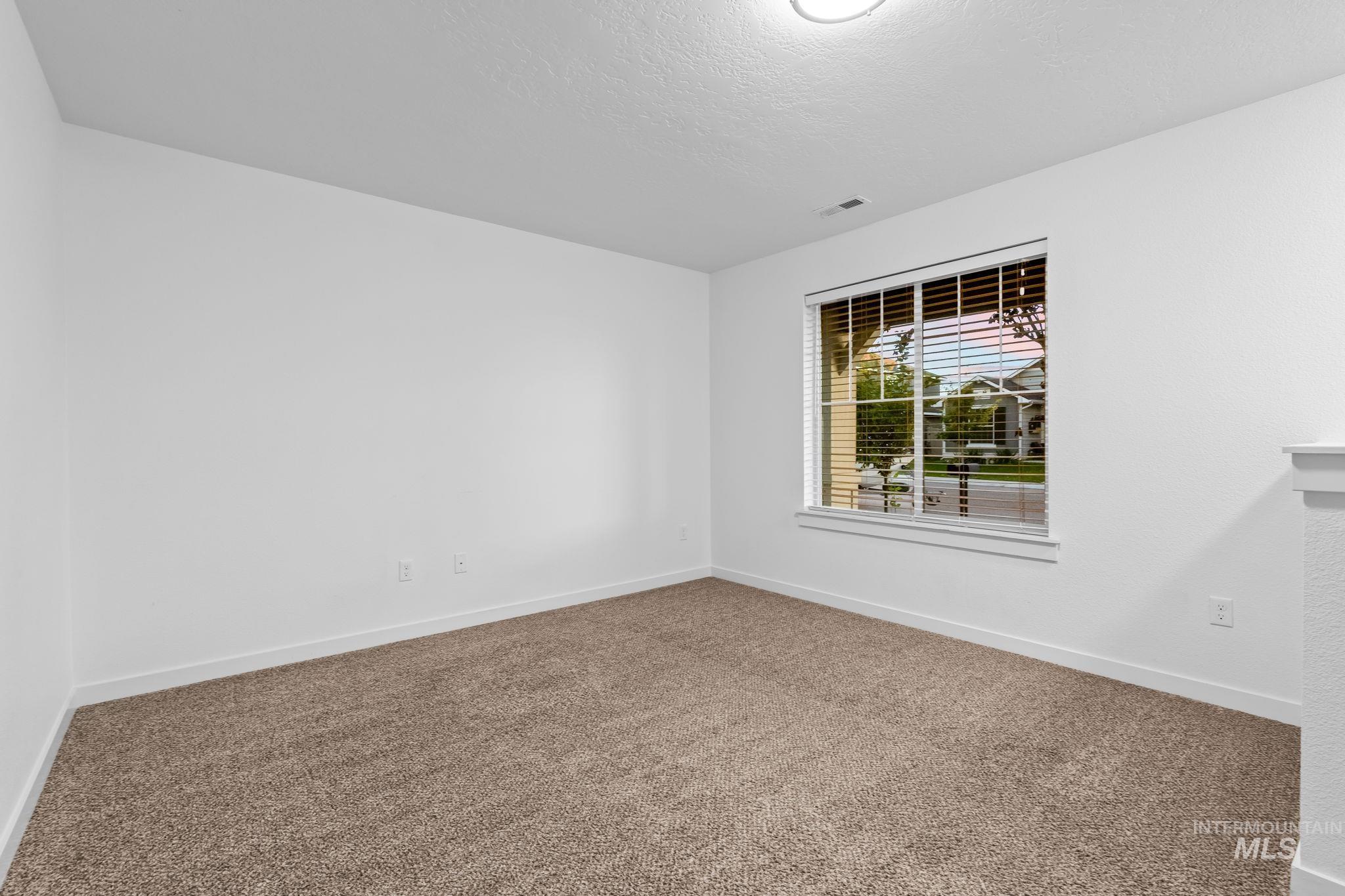Carpeted spare room with baseboards and a textured ceiling