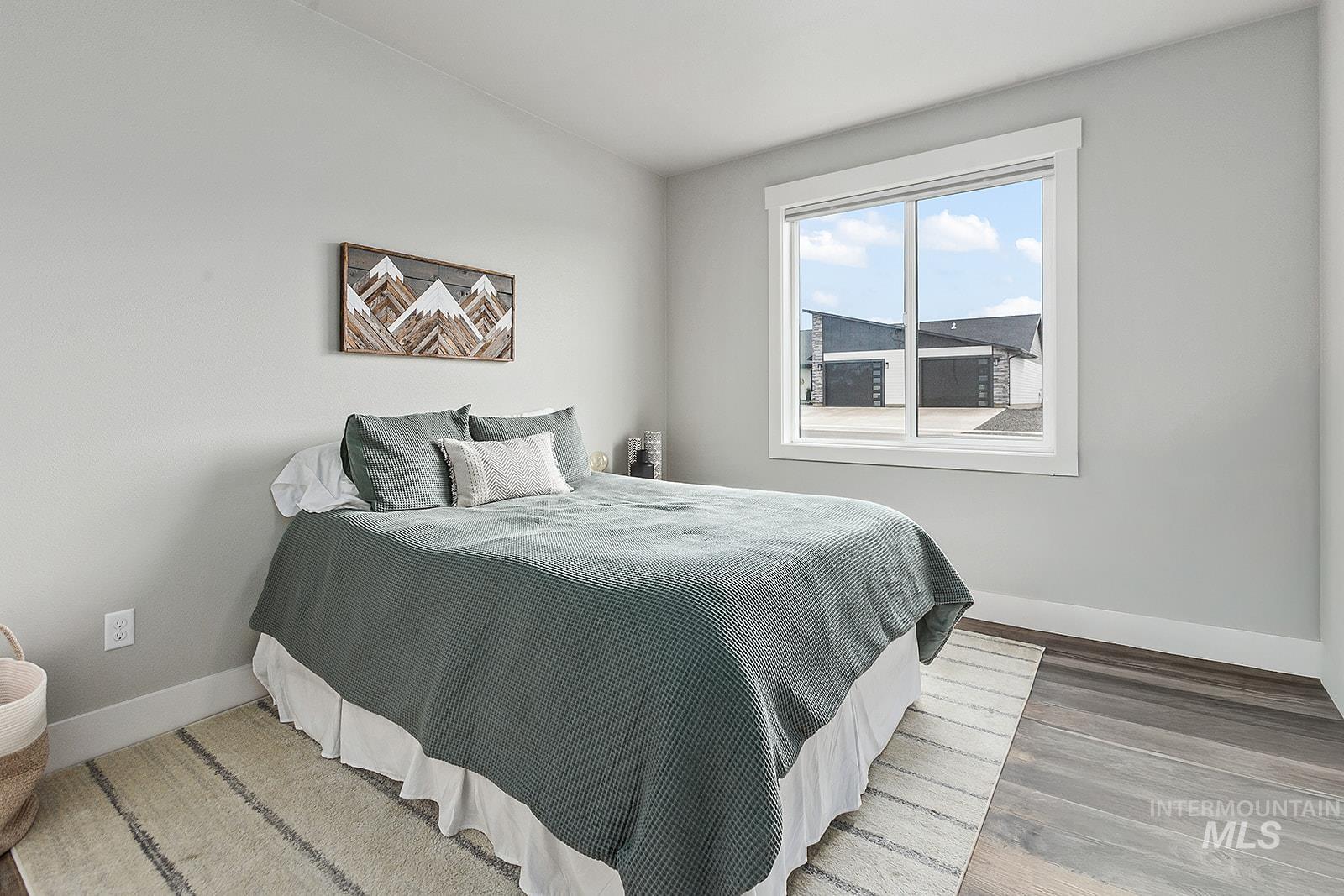 Bedroom featuring baseboards and wood finished floors