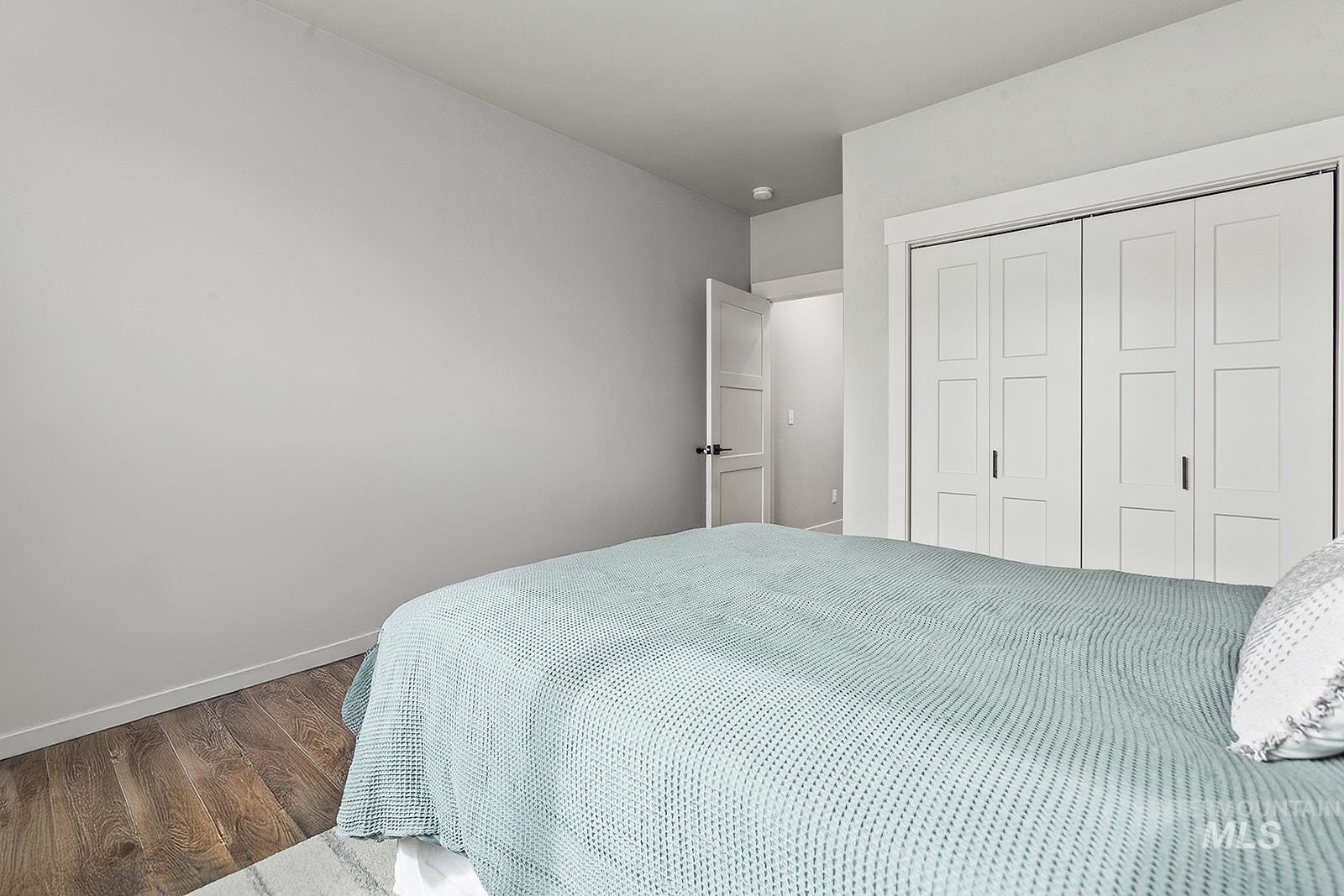 Bedroom with wood finished floors and a closet