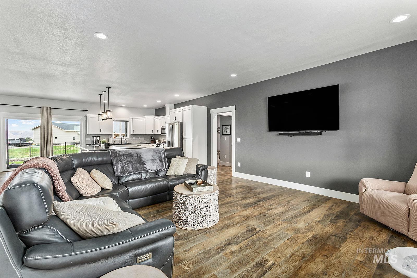 Living area with recessed lighting and dark wood-style floors