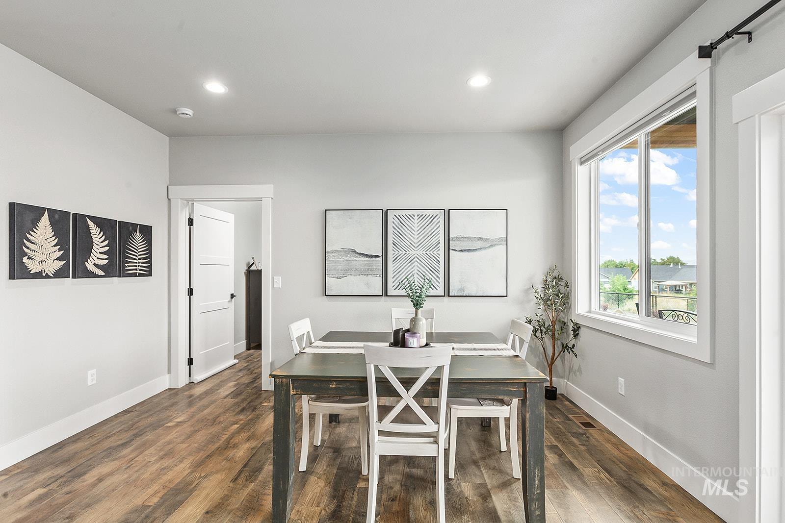 Dining area featuring dark wood-style flooring and recessed lighting