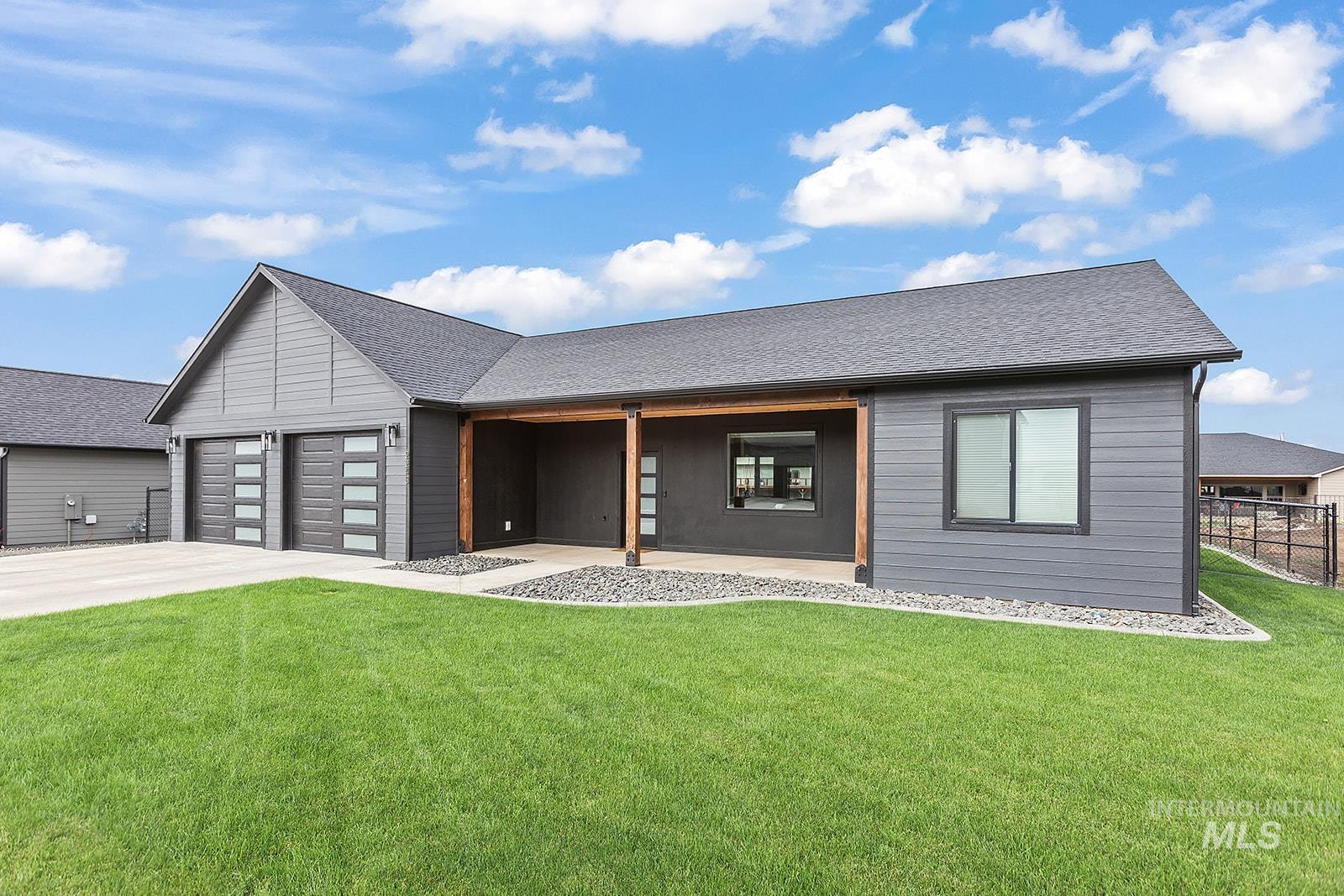 Modern home featuring a shingled roof, driveway, and a garage