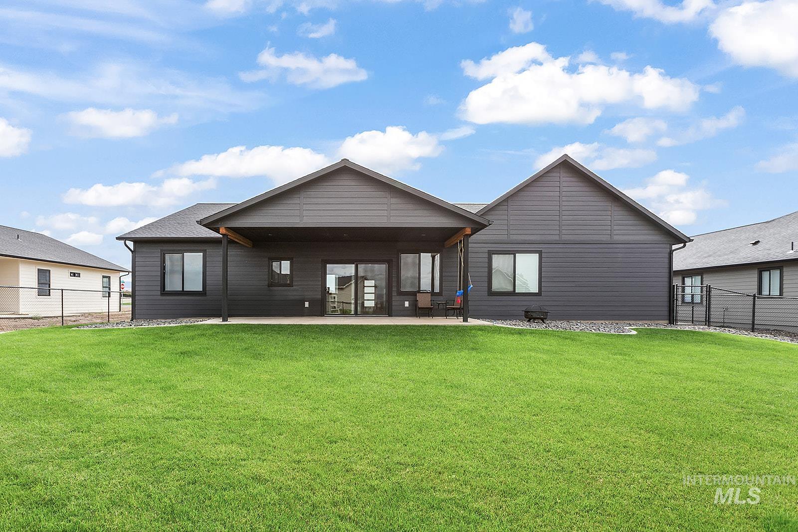 Back of house with a fenced backyard and a patio
