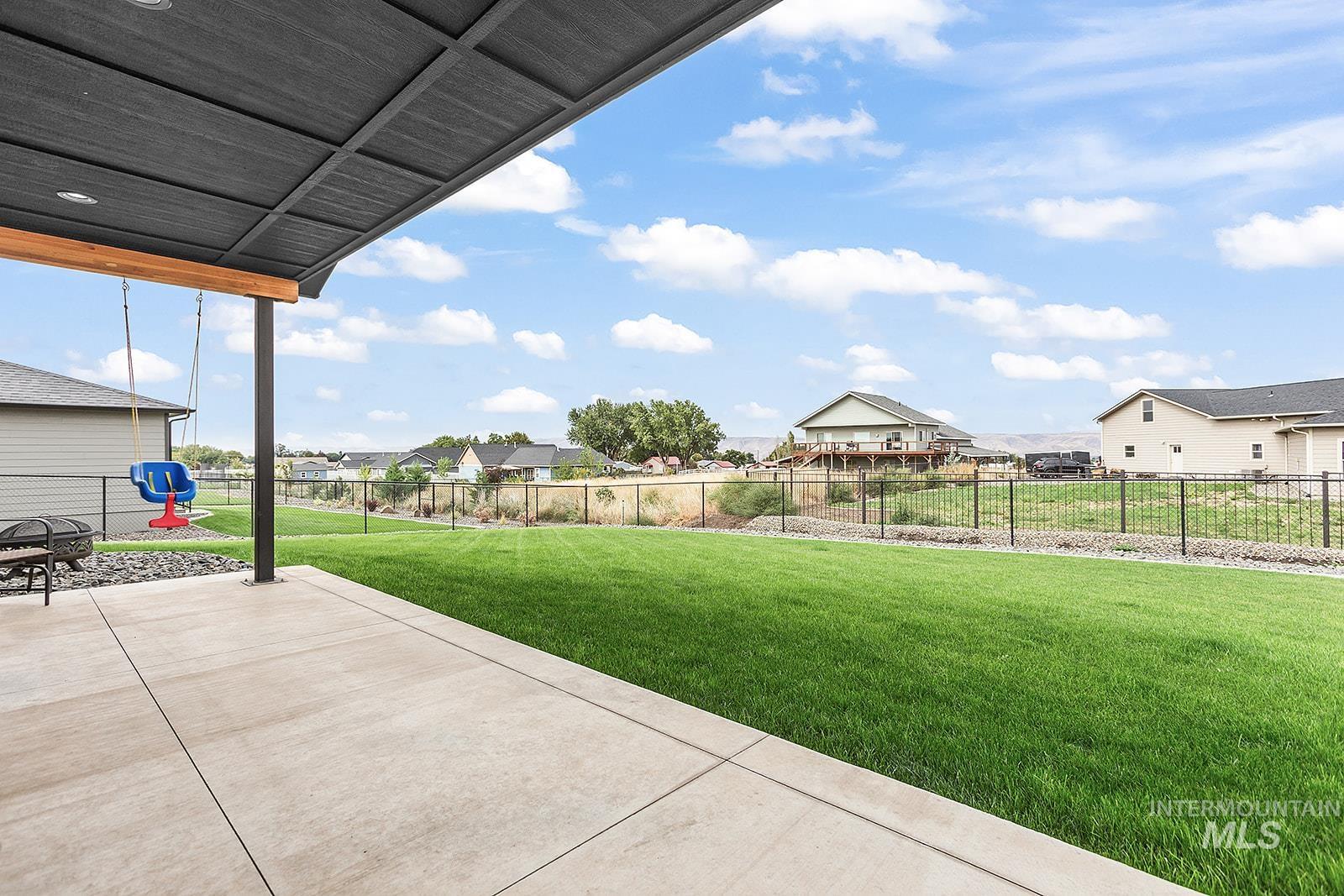 Fenced backyard featuring a patio and a residential view
