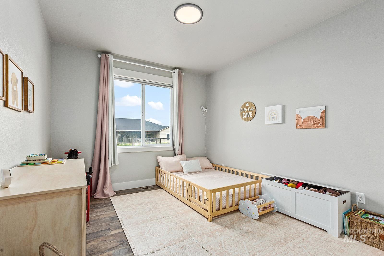 Bedroom featuring wood finished floors and baseboards