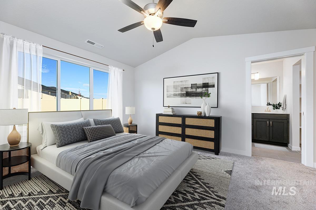 Bedroom featuring light carpet, lofted ceiling, ceiling fan, and ensuite bath