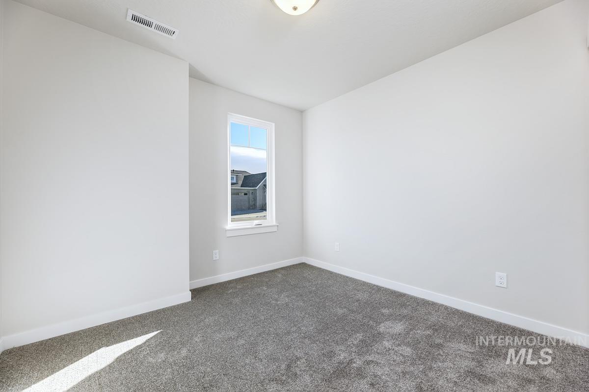 Spare room featuring carpet floors and baseboards