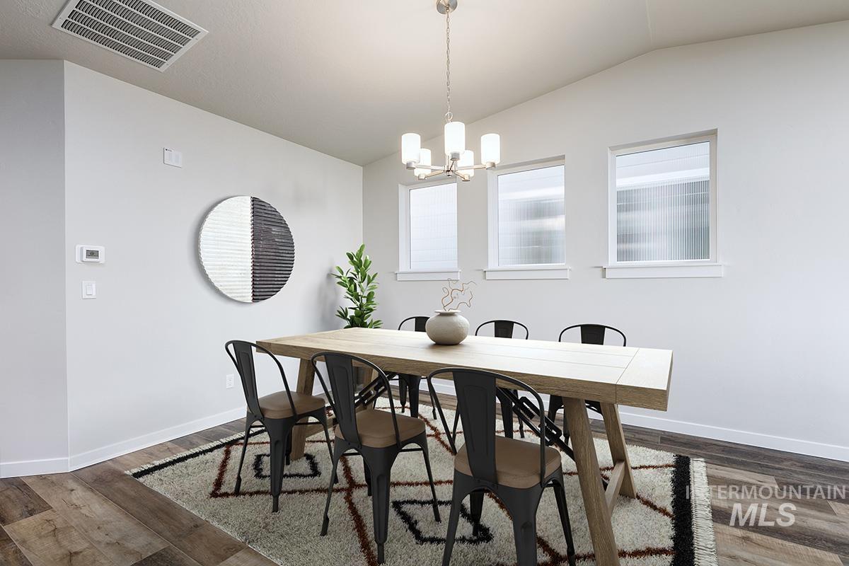Dining space featuring vaulted ceiling, dark wood-type flooring, and a chandelier