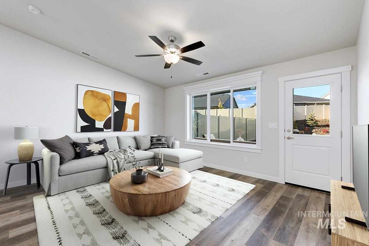 Living room with dark wood finished floors, vaulted ceiling, and ceiling fan