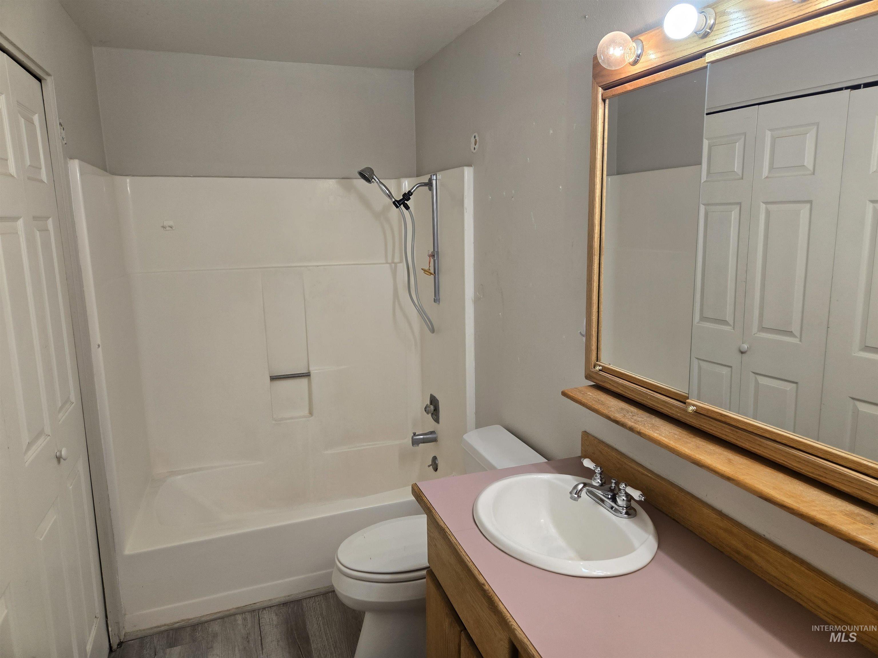Full bathroom with vanity, bathtub / shower combination, and wood finished floors