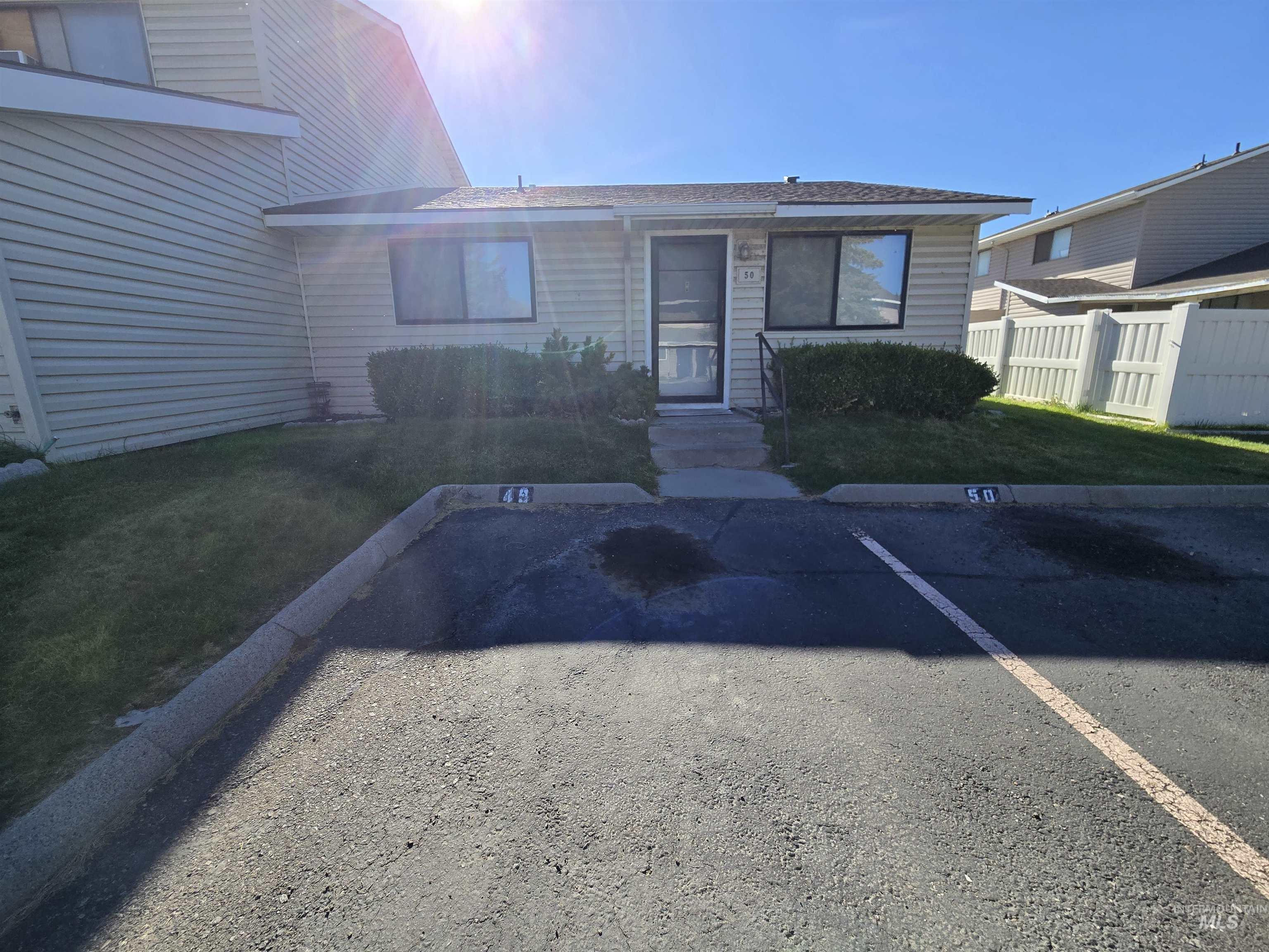 View of exterior entry featuring uncovered parking and roof with shingles