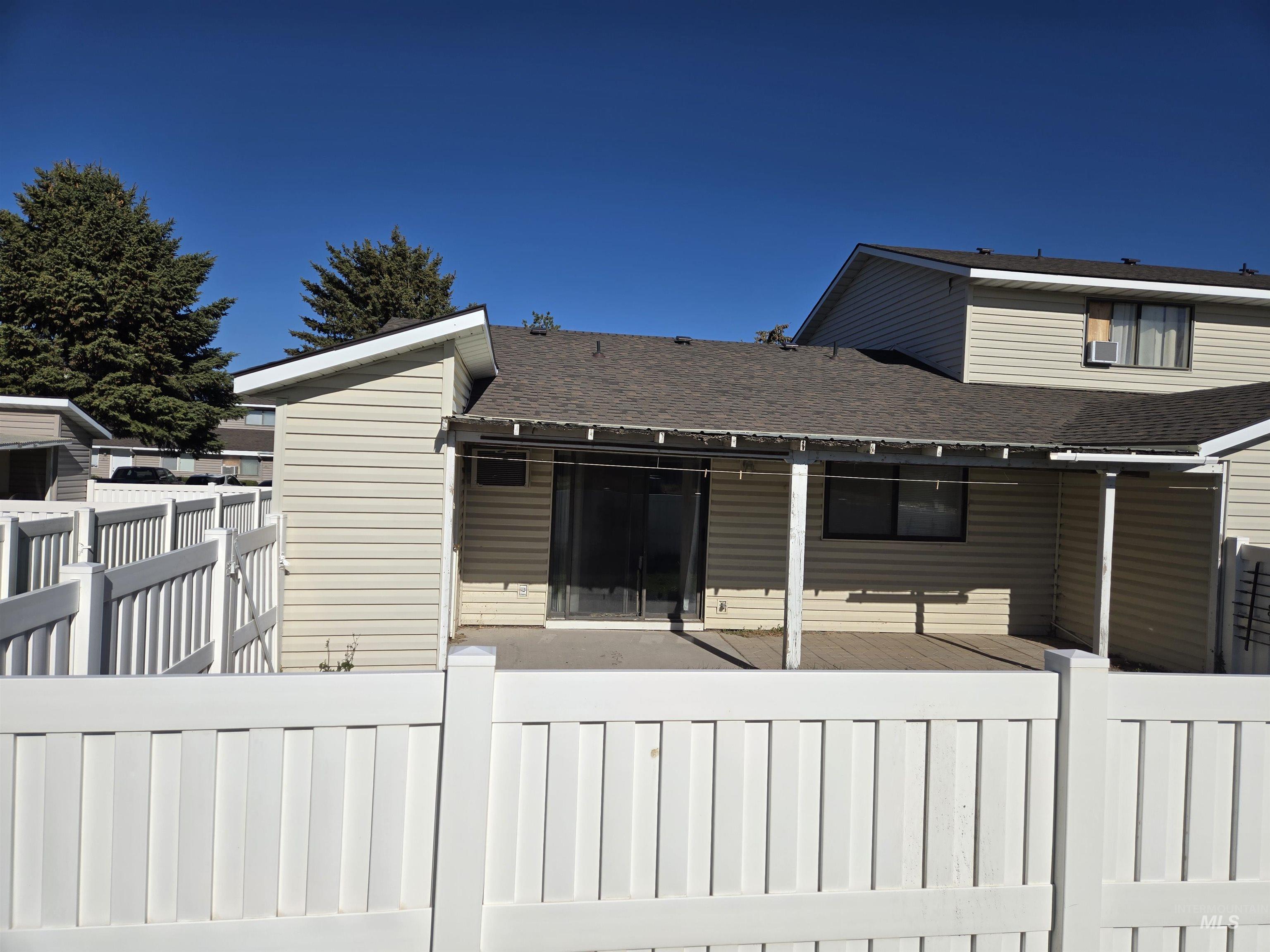 Back of house with a fenced backyard, a shingled roof, and a deck