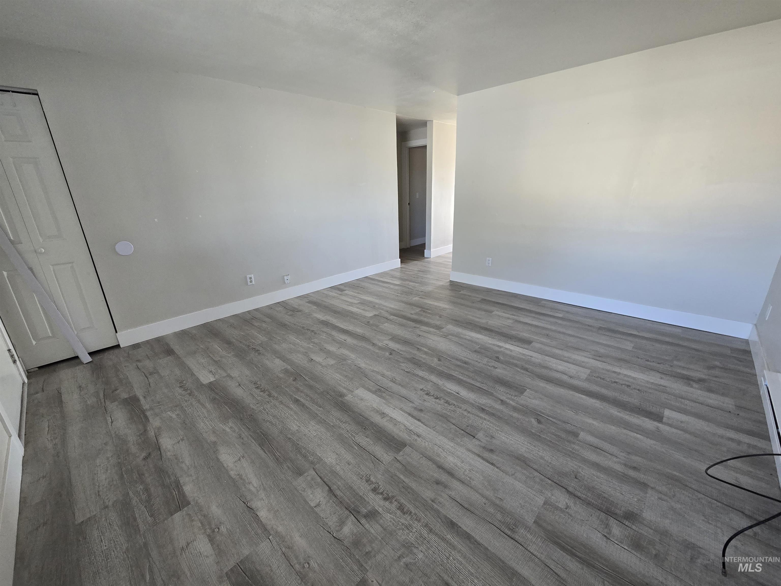 Empty room featuring wood finished floors and baseboards