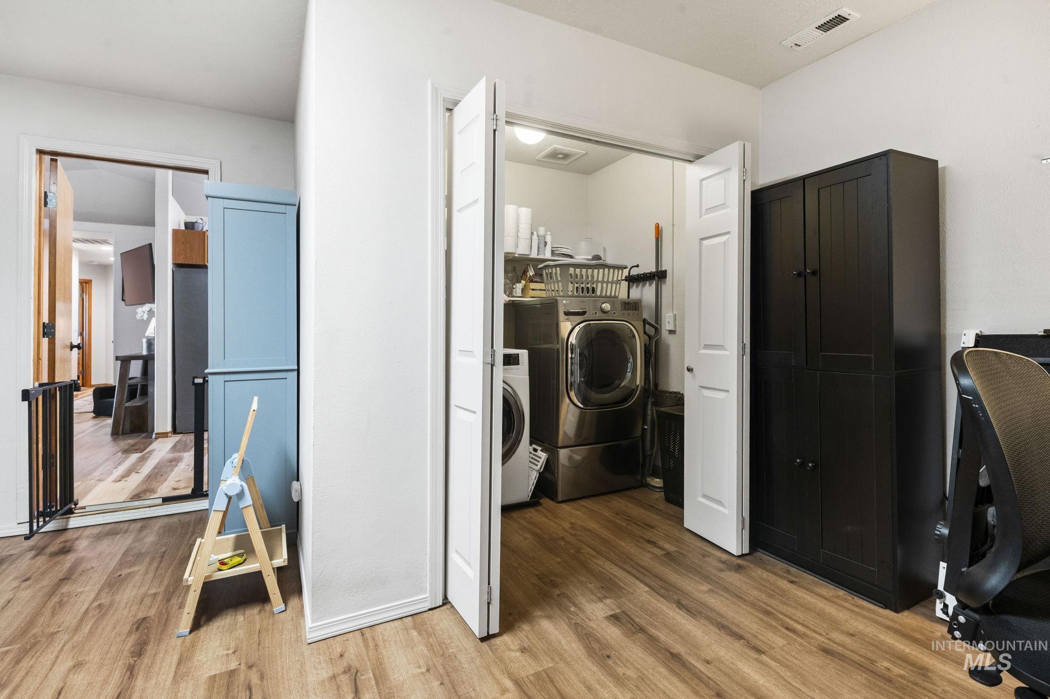 Washroom featuring light wood finished floors and washing machine and dryer