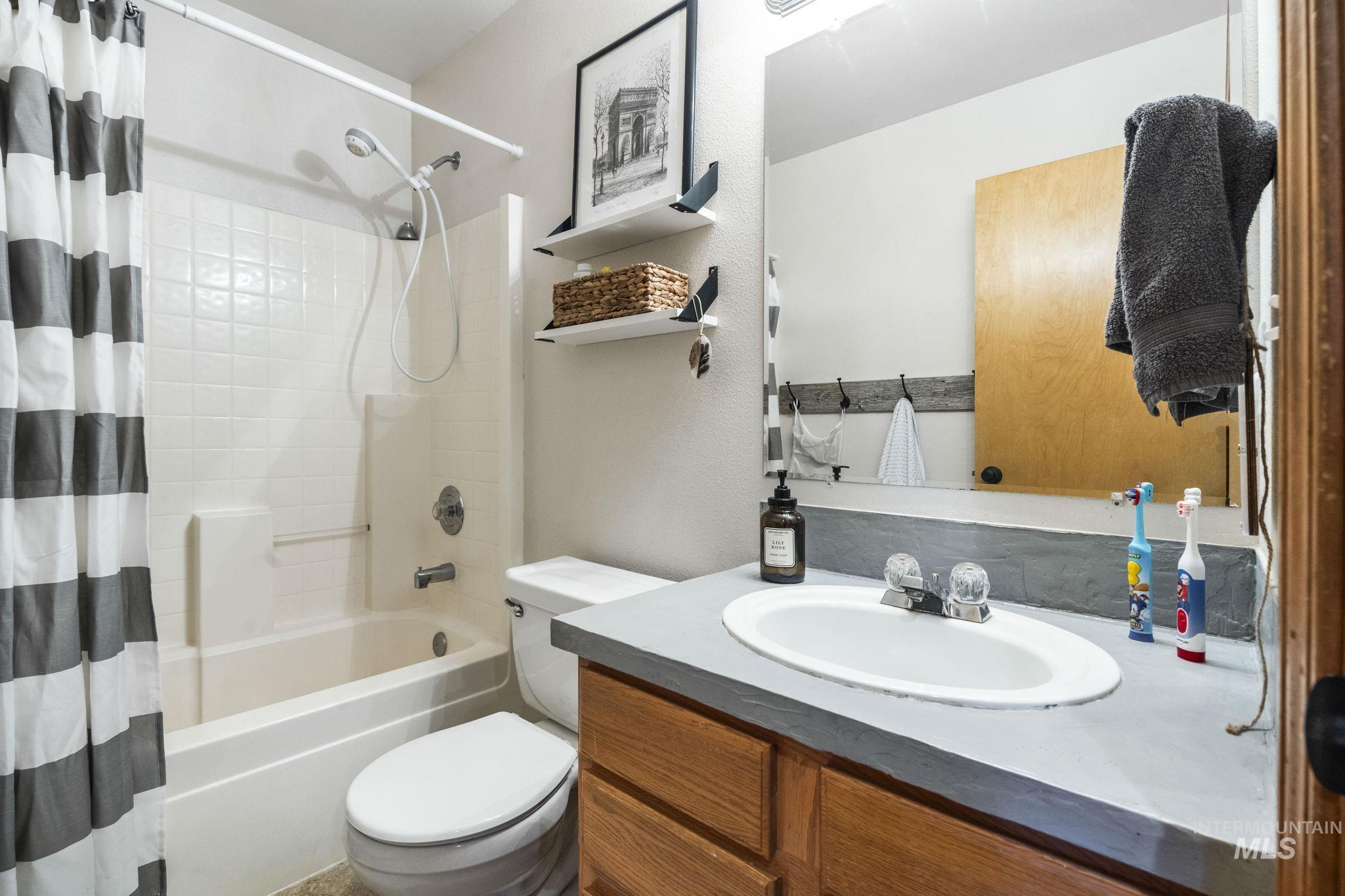 Full bathroom featuring shower / bath combo with shower curtain and vanity