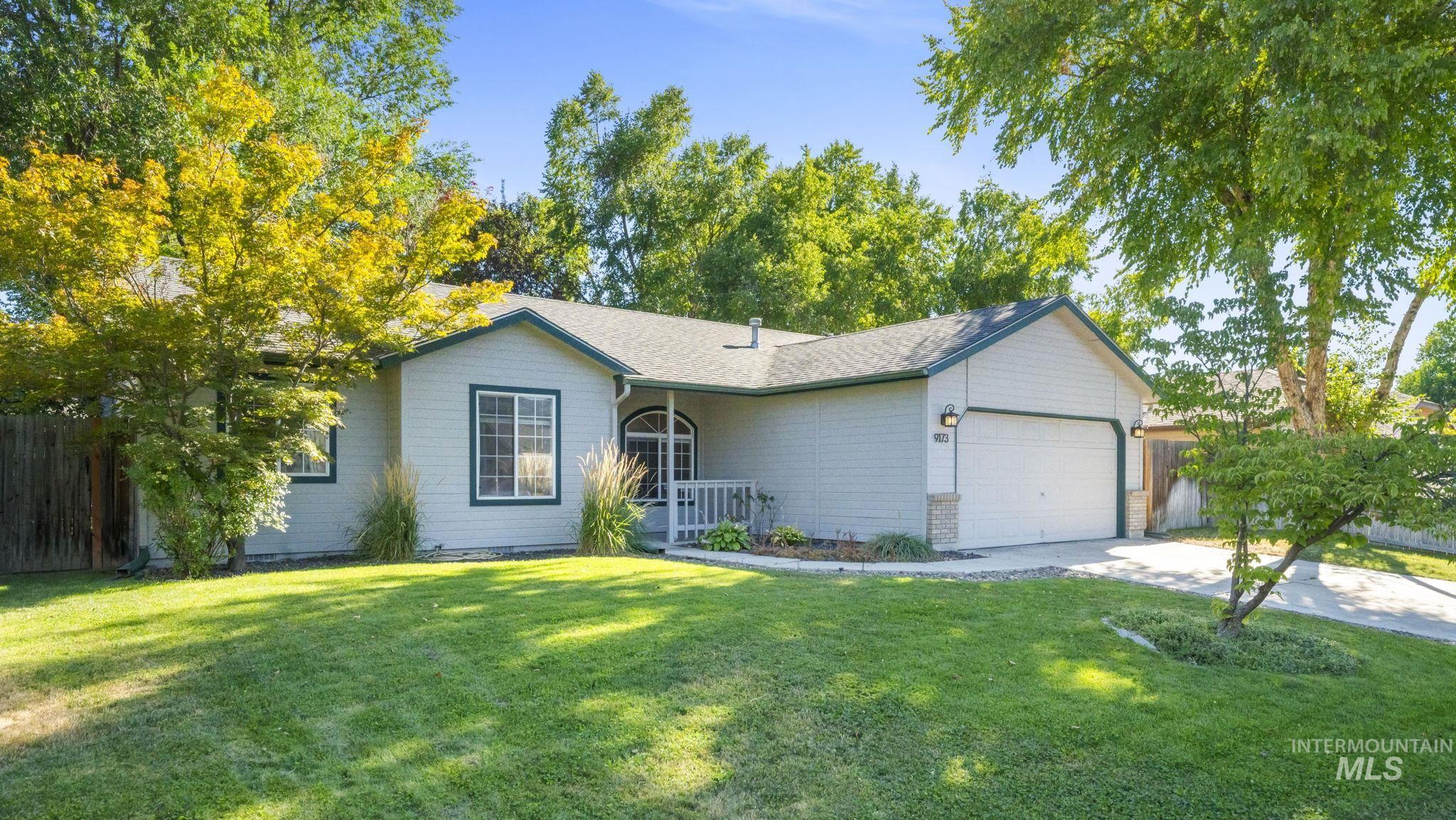 Ranch-style house featuring a garage, driveway, and roof with shingles