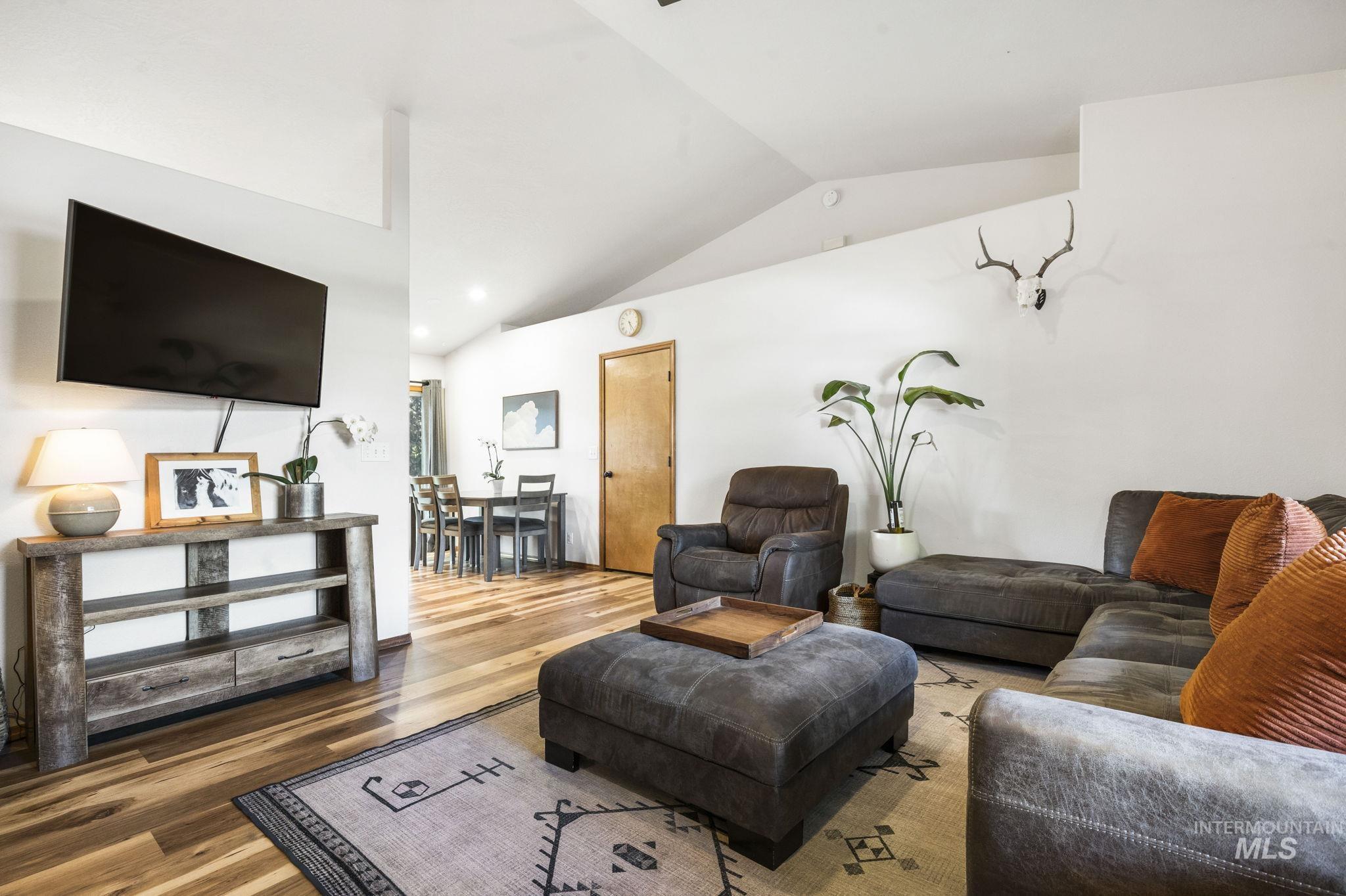 Living area with lofted ceiling, wood finished floors, and recessed lighting
