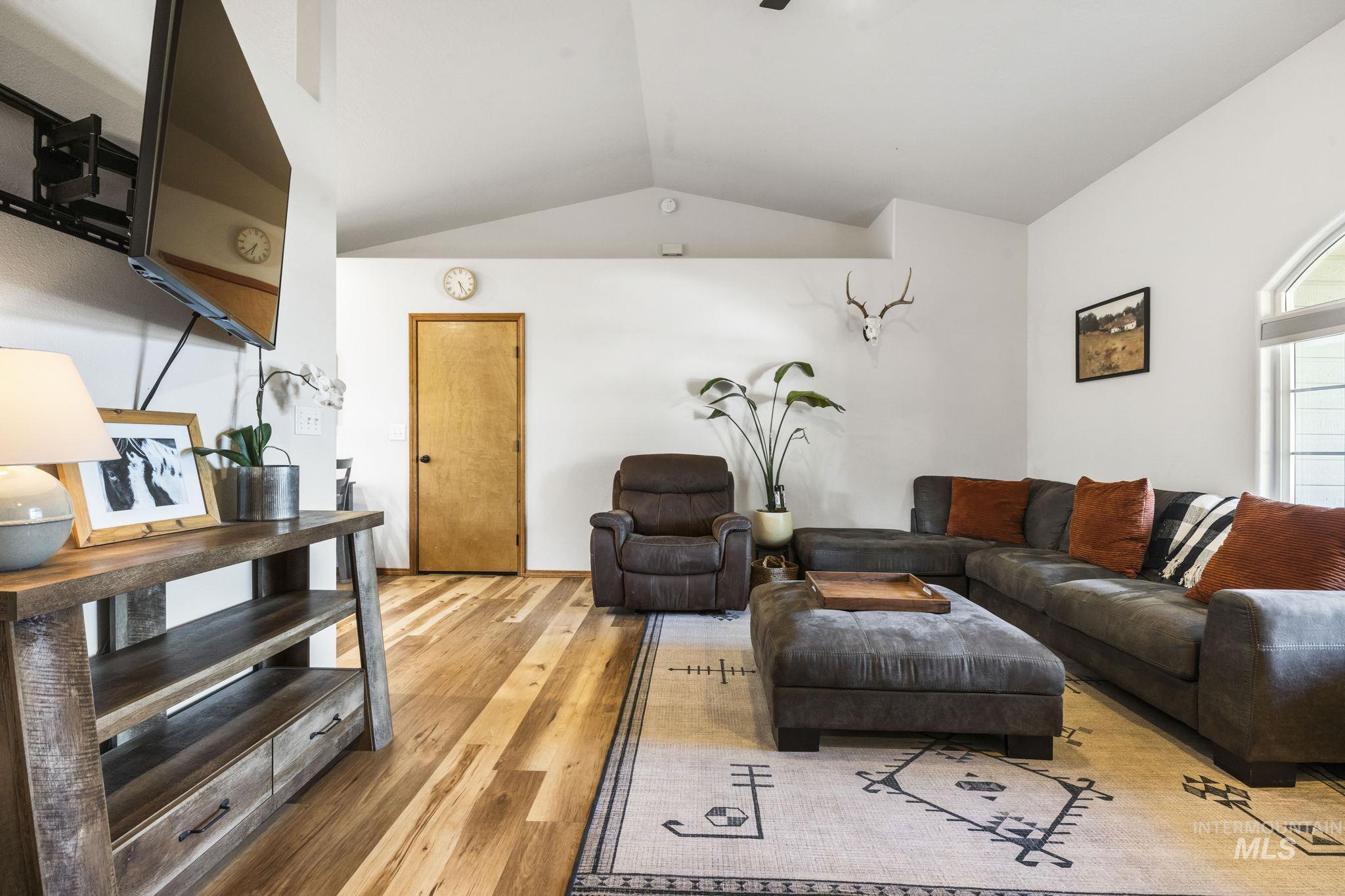 Living room featuring lofted ceiling and light wood-style floors
