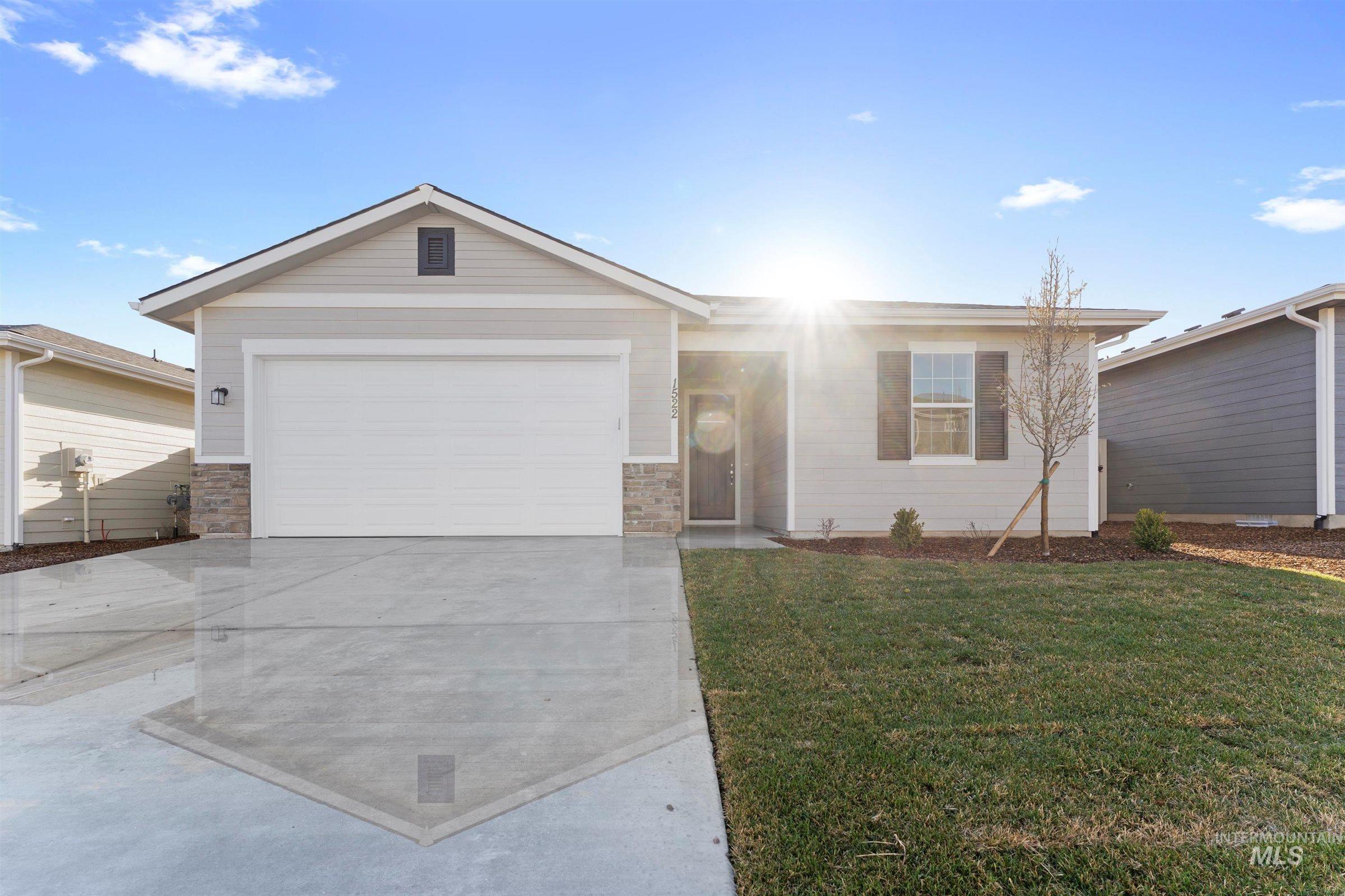 Ranch-style house featuring concrete driveway, a front lawn, an attached garage, and stone siding
