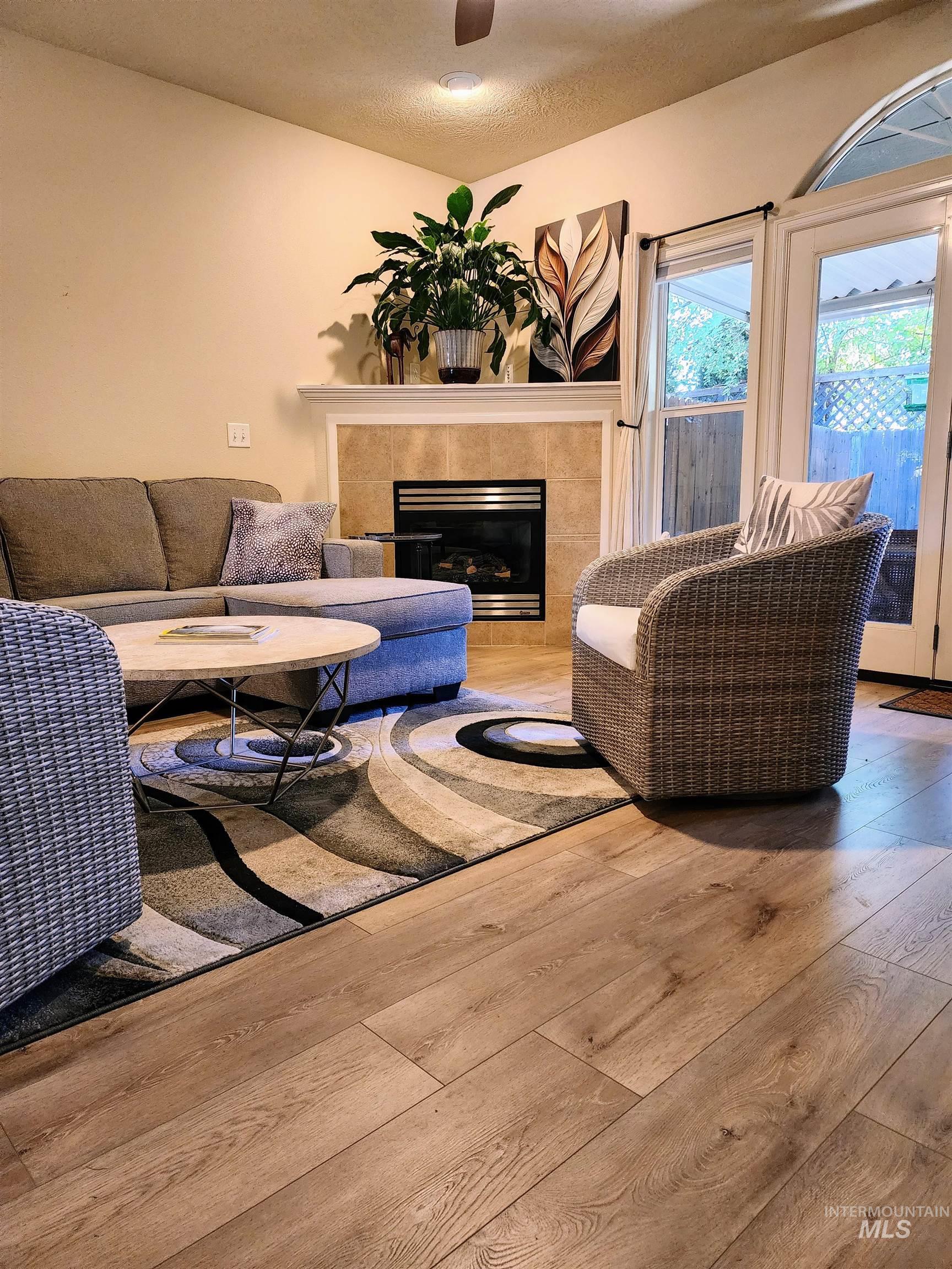 Living area featuring a fireplace, hardwood / wood-style floors, and a textured ceiling