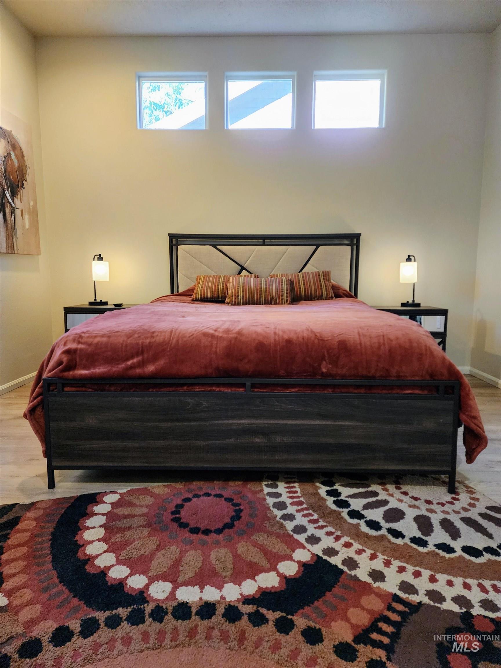 Bedroom featuring light wood finished floors and multiple windows