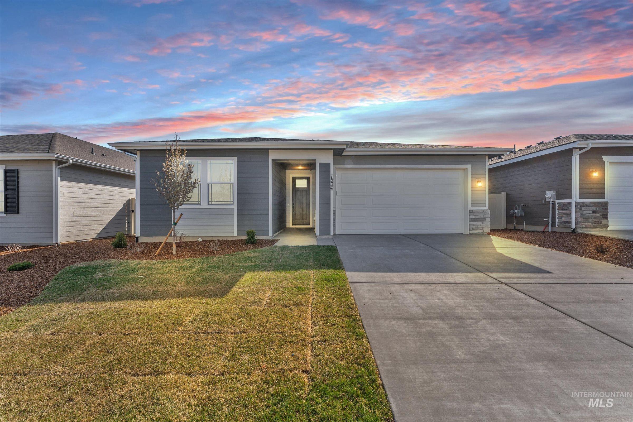 Single story home with concrete driveway, a garage, and a yard