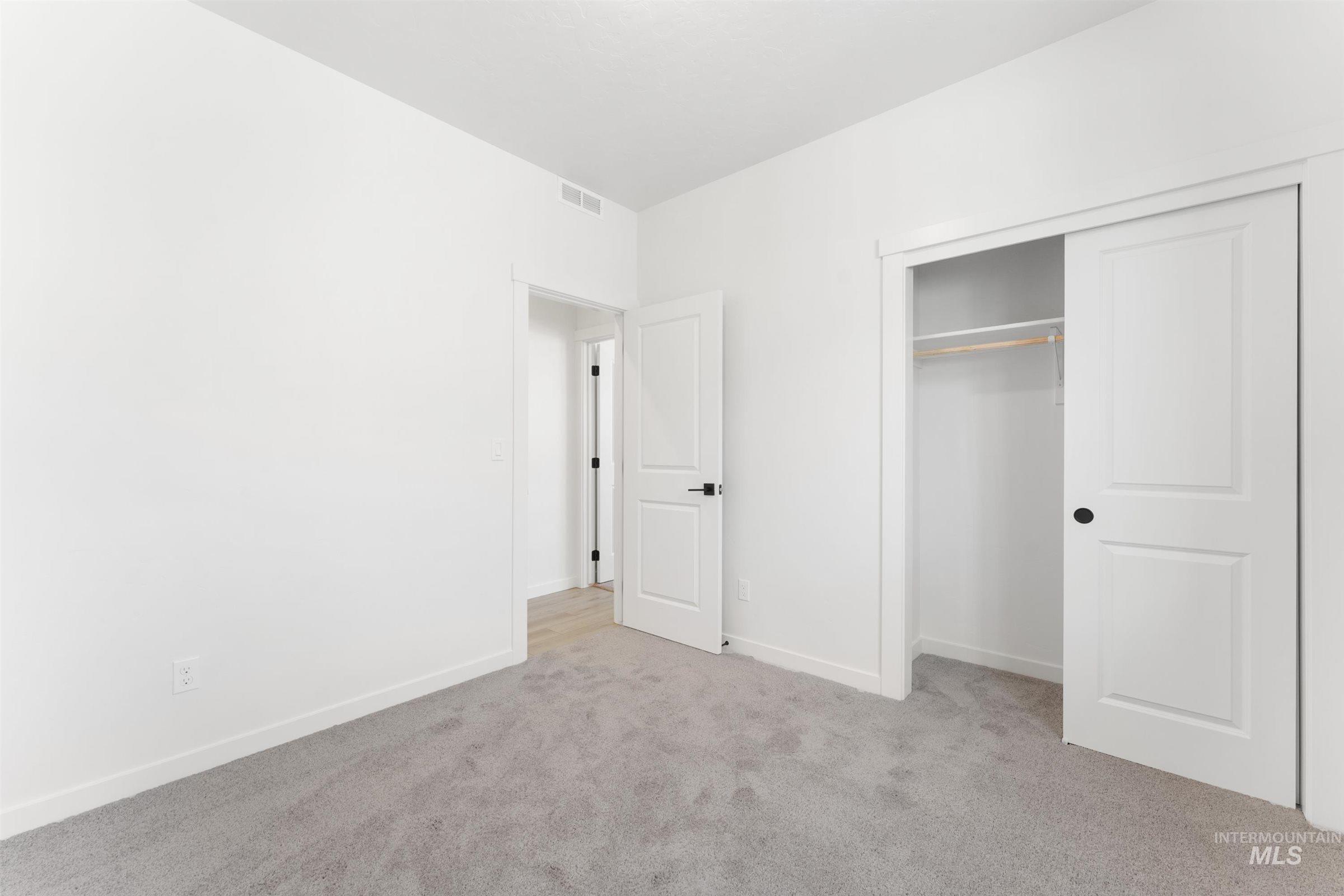 Unfurnished bedroom with carpet and a closet