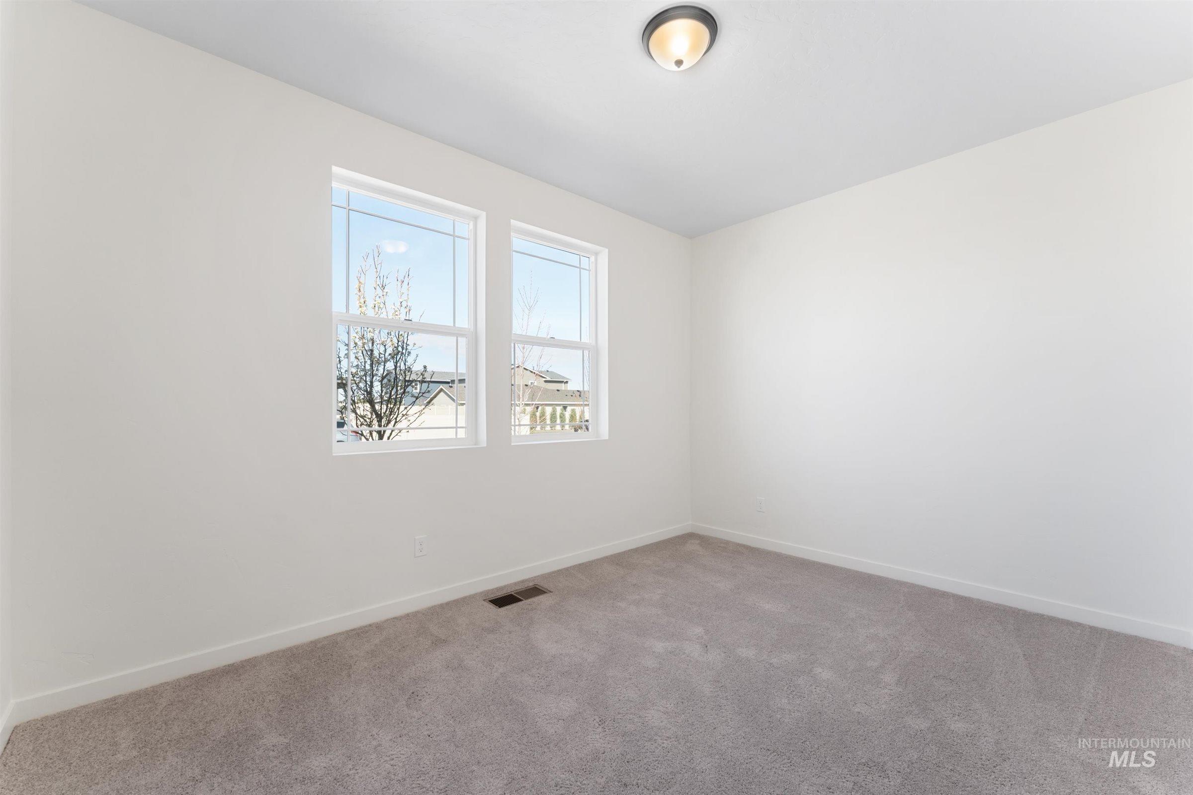 Spare room featuring light colored carpet and baseboards