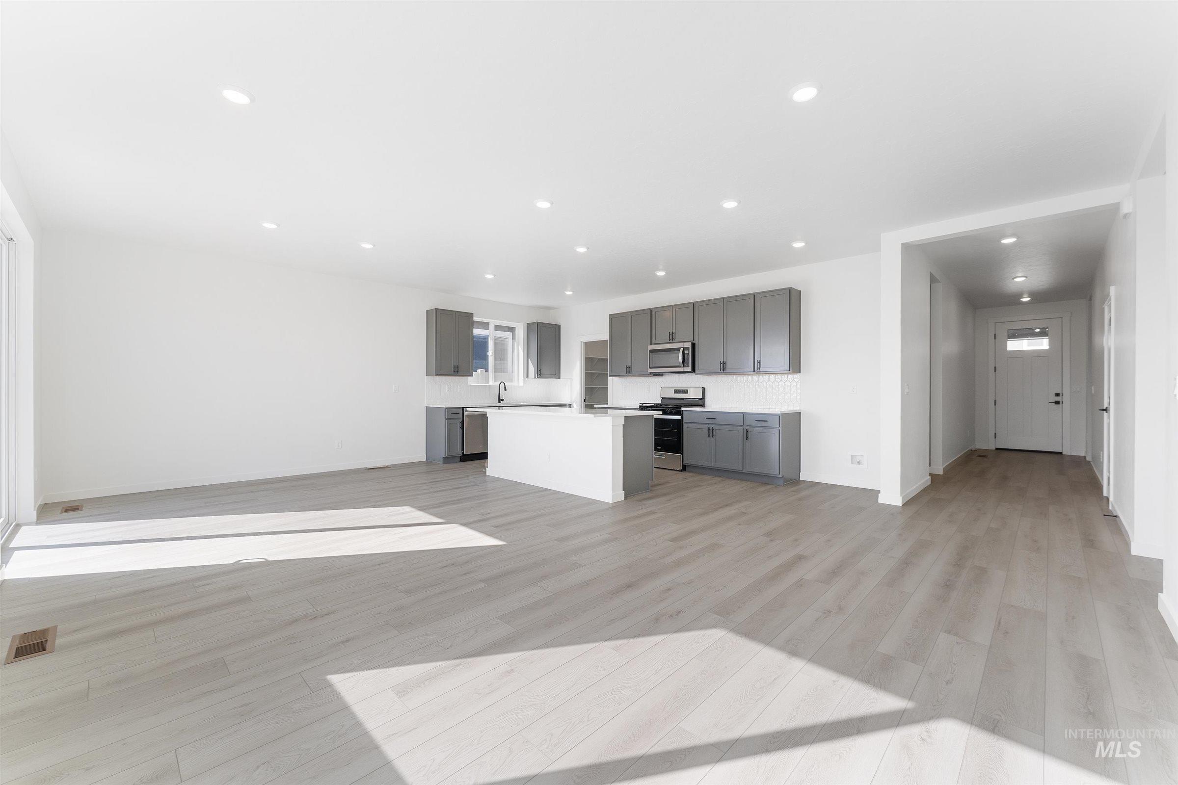 Unfurnished living room with light wood finished floors and recessed lighting