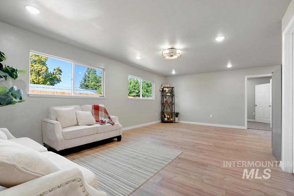 Living room with recessed lighting and light wood-type flooring