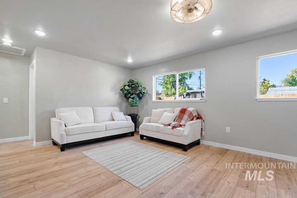 Living area featuring light wood-style floors, recessed lighting, and attic access