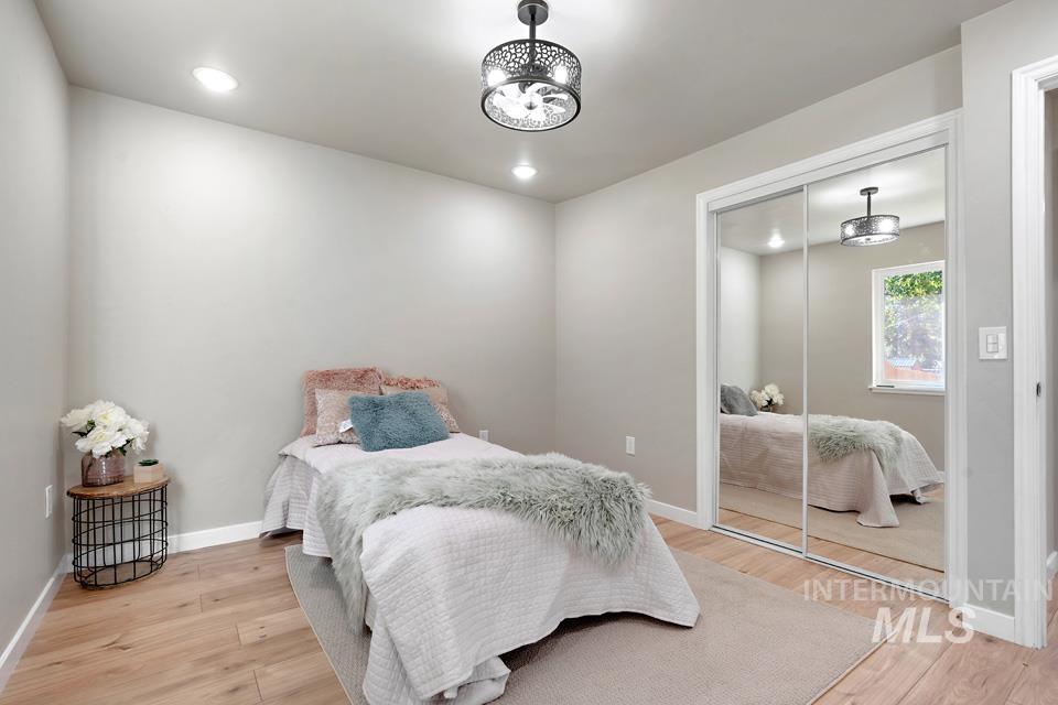 Bedroom with light wood-style floors, a closet, and recessed lighting