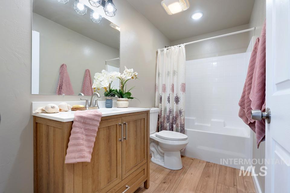 Full bath featuring light wood-style floors, vanity, and shower / tub combo