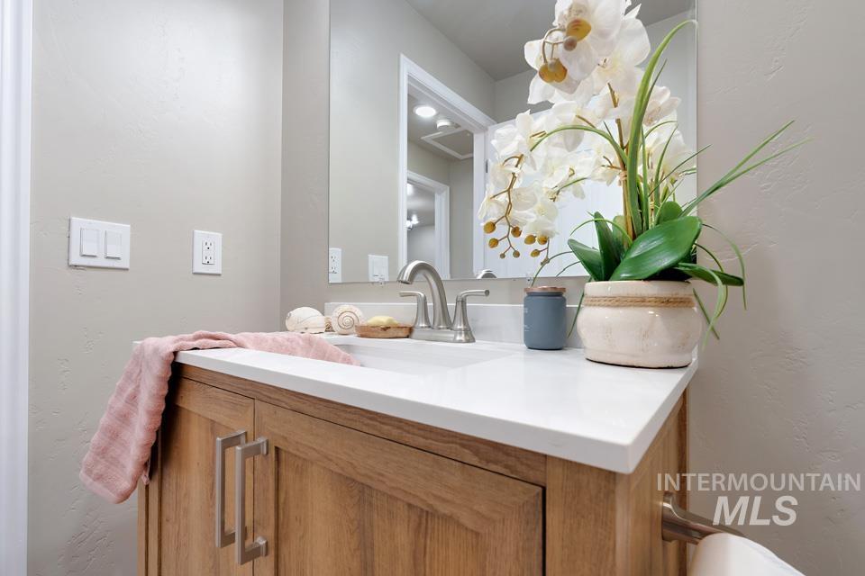 Bathroom featuring a textured wall and vanity