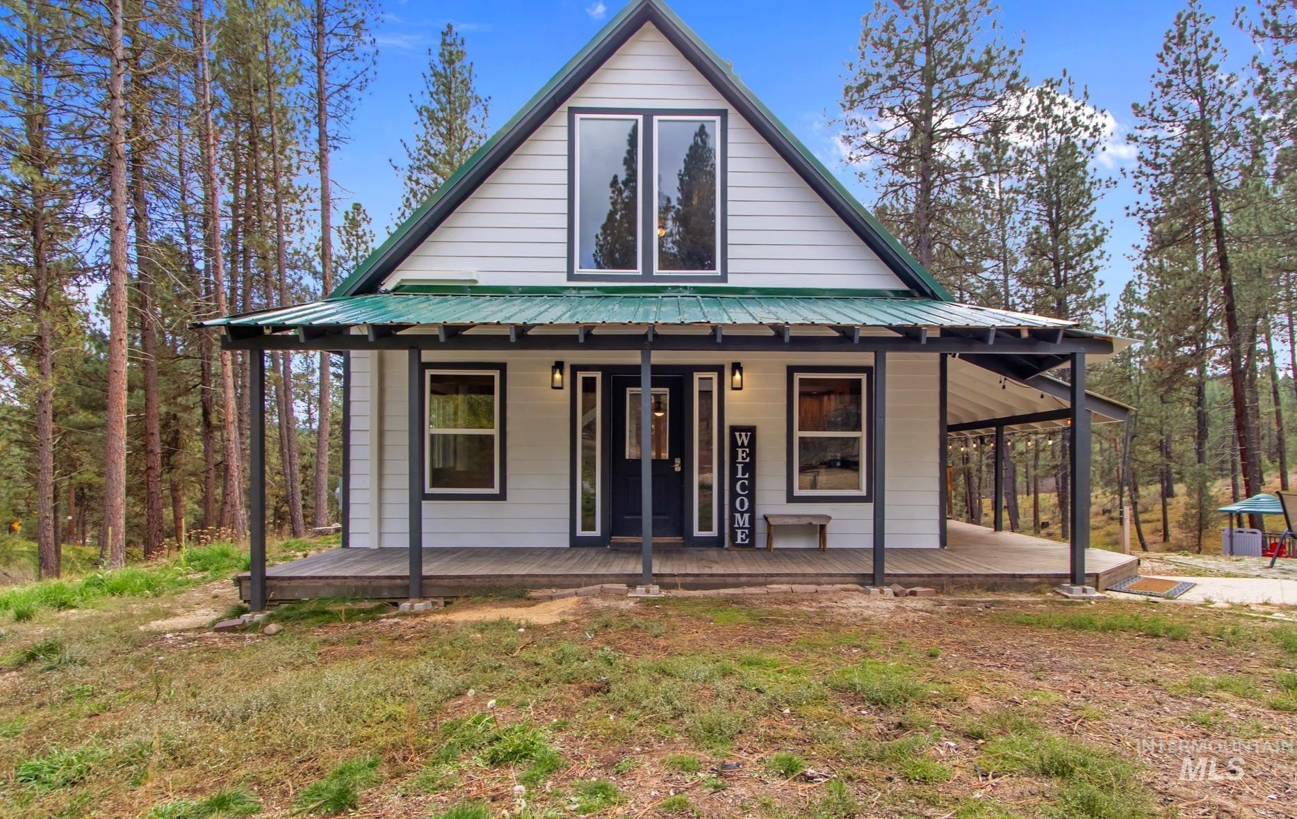 View of front of house featuring covered porch and a metal roof