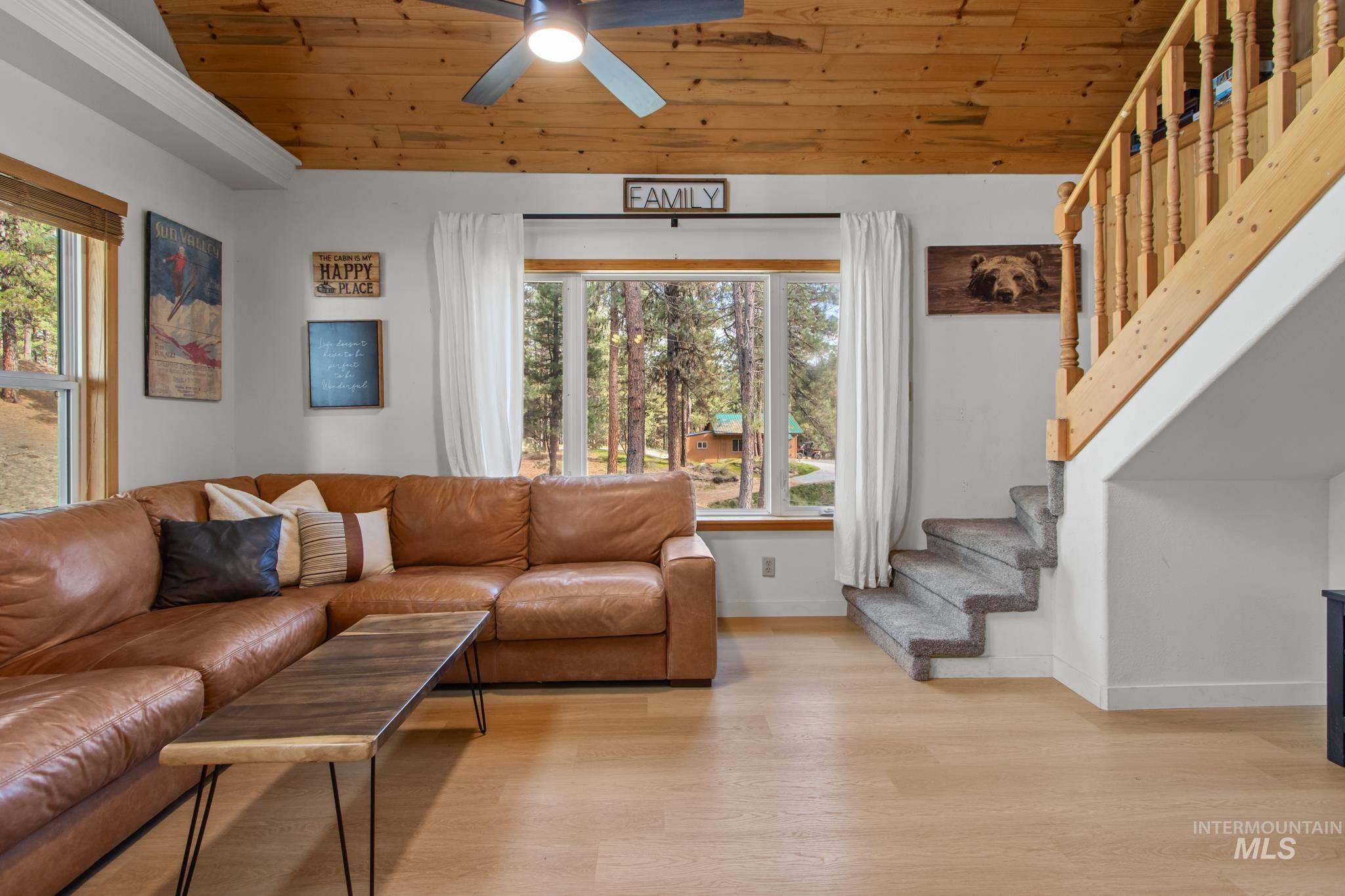 Living area featuring wooden ceiling, light wood-type flooring, stairway, and ceiling fan
